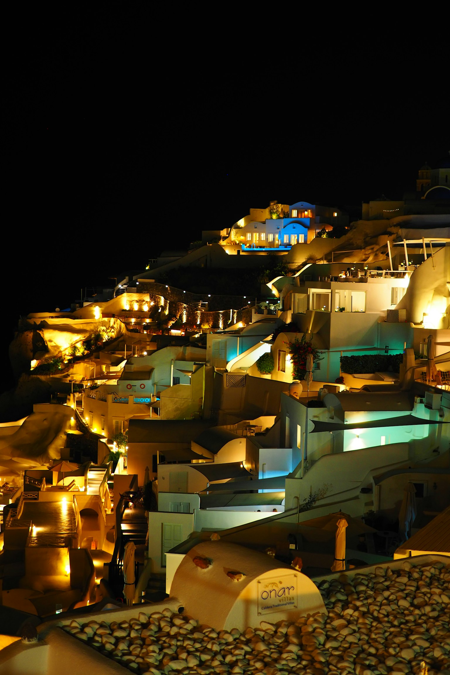 Cảnh đêm đẹp của Santorini với các tòa nhà được chiếu sáng và đèn
