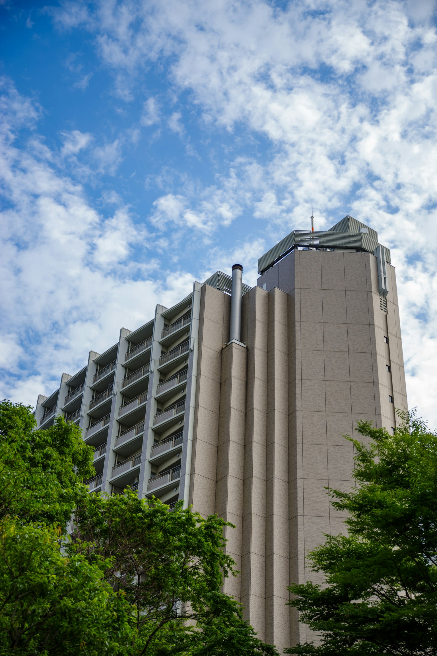 Edificio alto contro un cielo blu circondato da alberi verdi