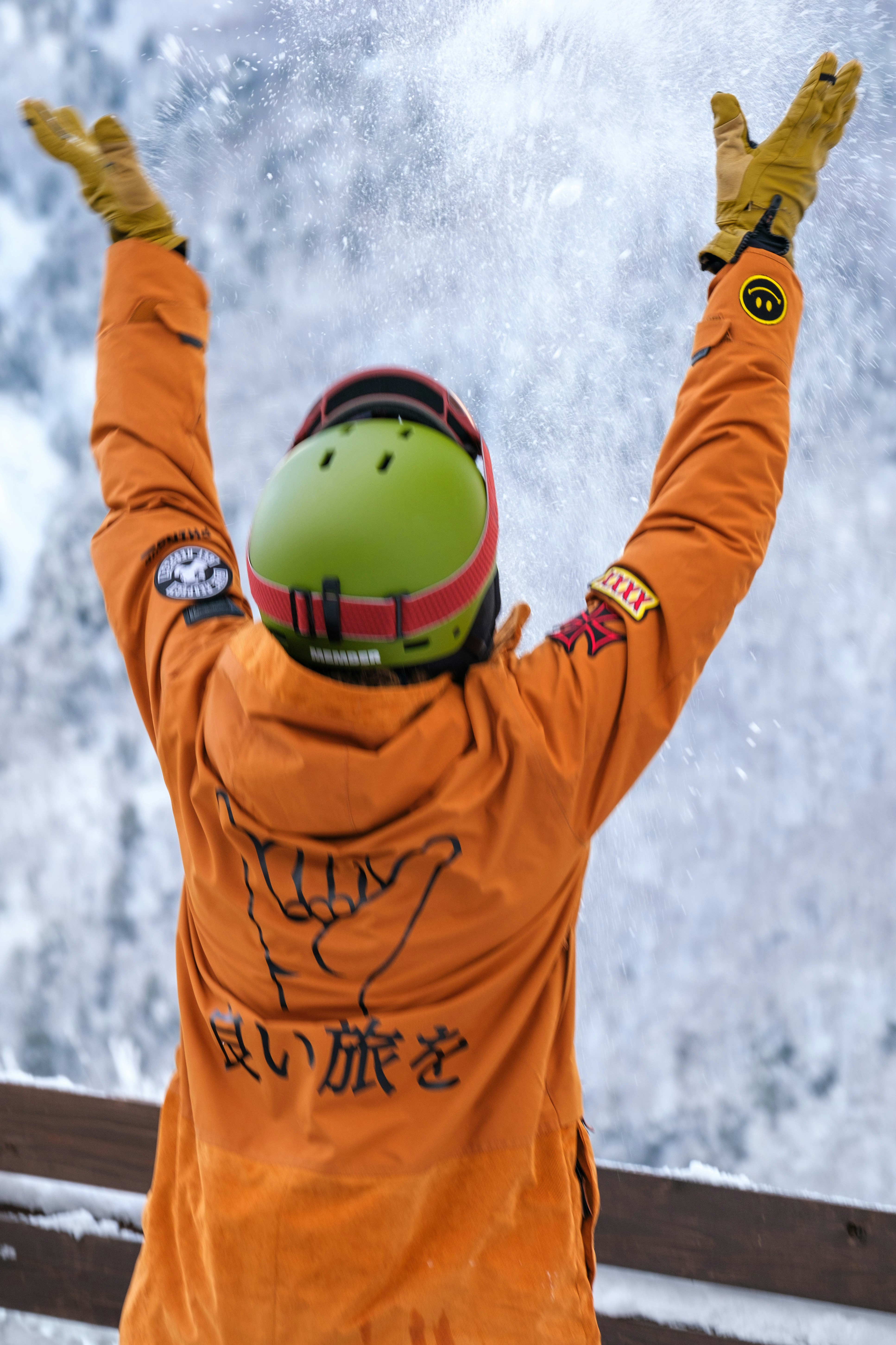 オレンジのスーツを着たスノーボーダーのジャンプ