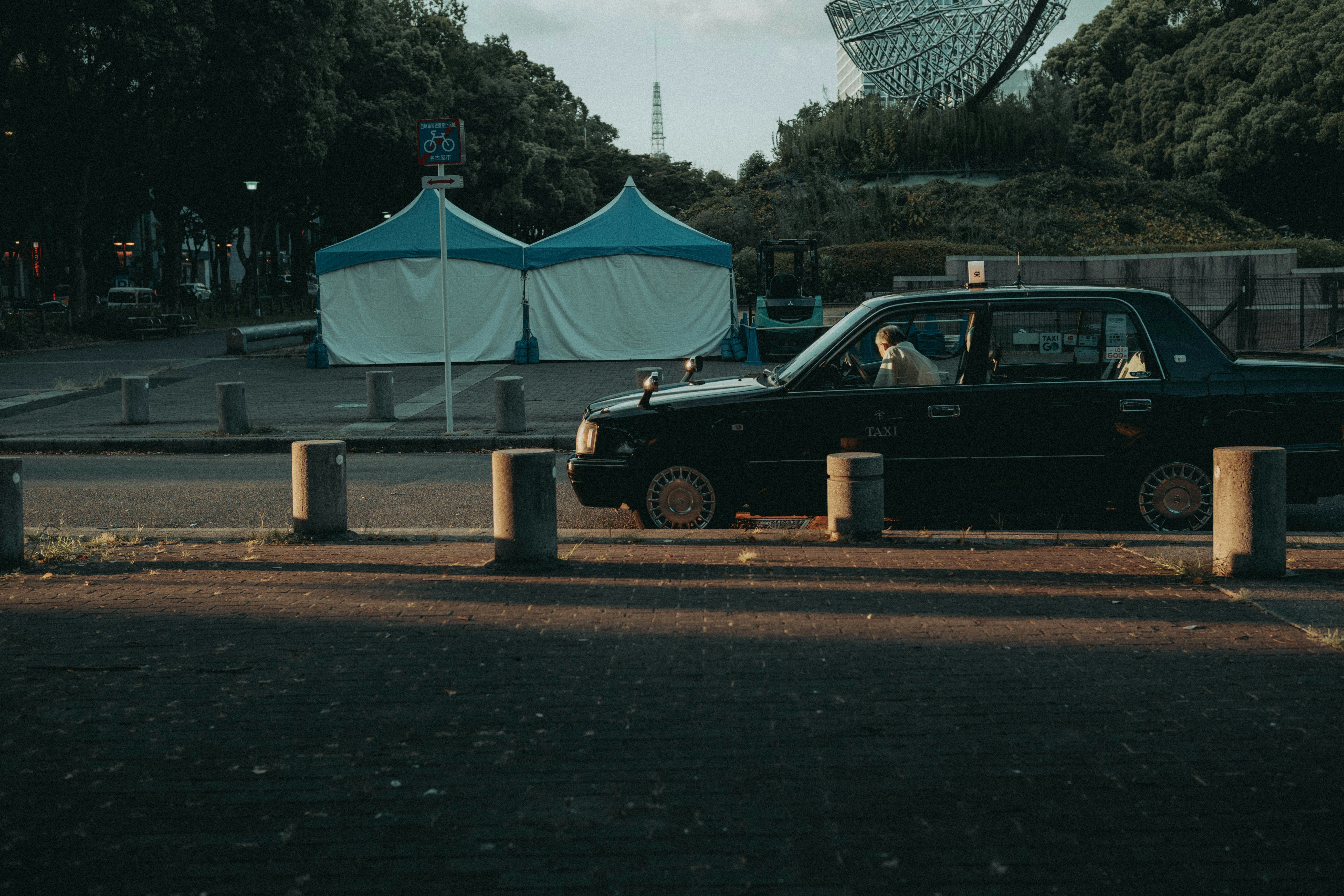 coche clásico estacionado en un aparcamiento de parque junto a tiendas de campaña