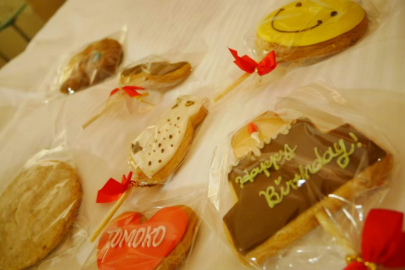 Galletas coloridas con mensajes de cumpleaños dispuestas sobre una superficie