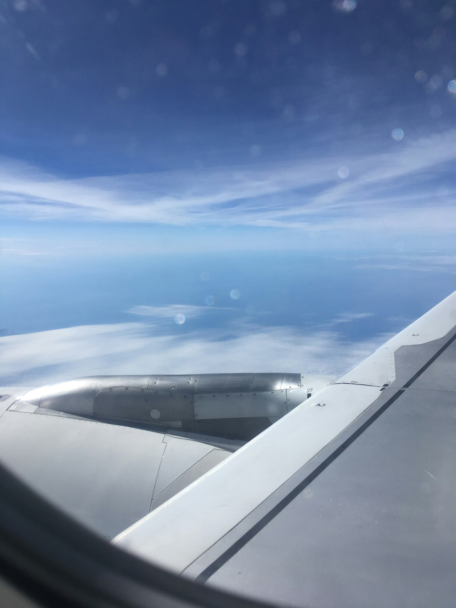 從飛機窗戶看到的景象 藍天和雲彩 顯示機翼的一部分