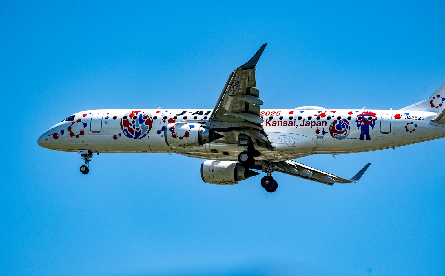 Aereo colorato che vola contro un cielo blu