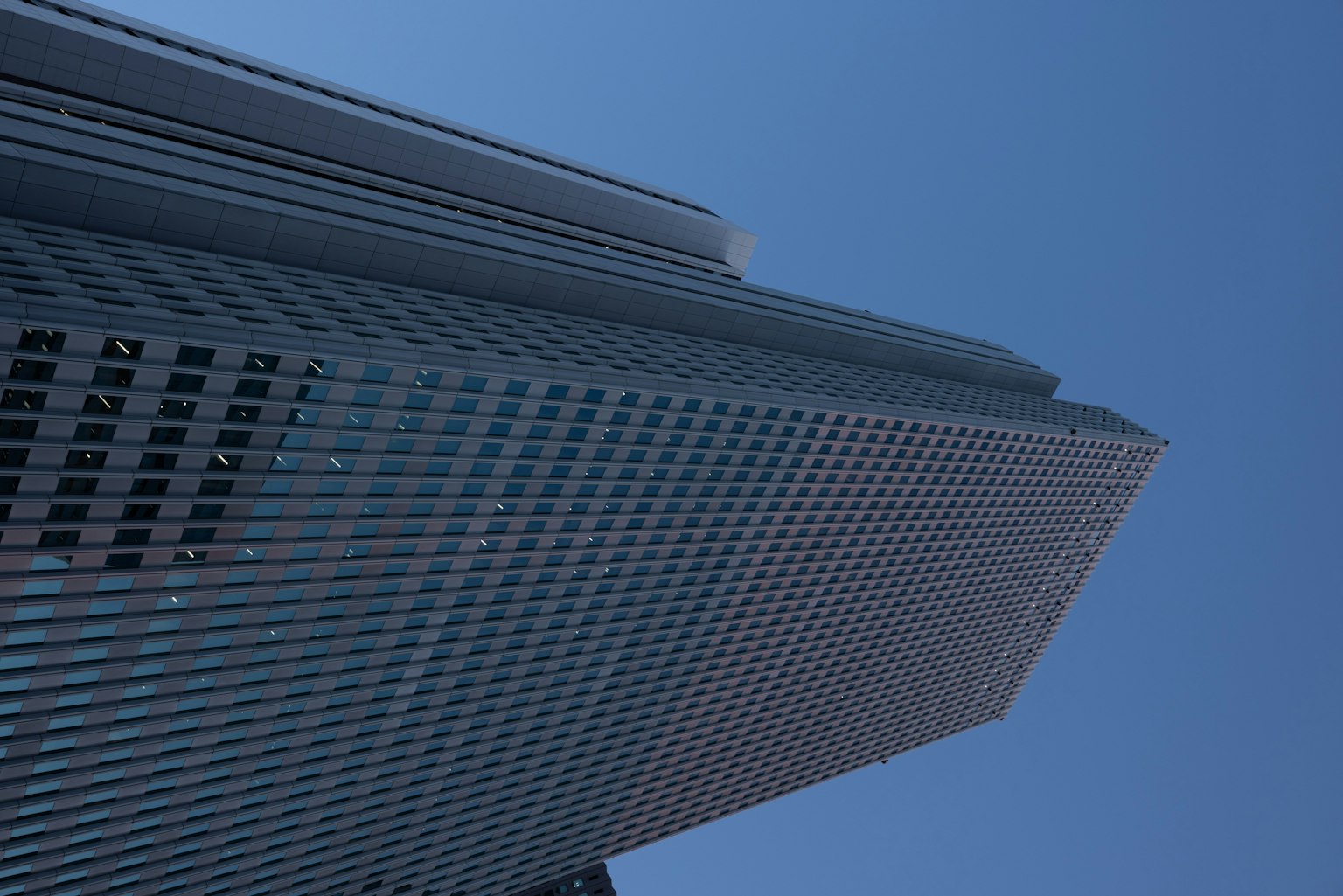 Vue d'un gratte-ciel depuis le bas sous un ciel bleu clair