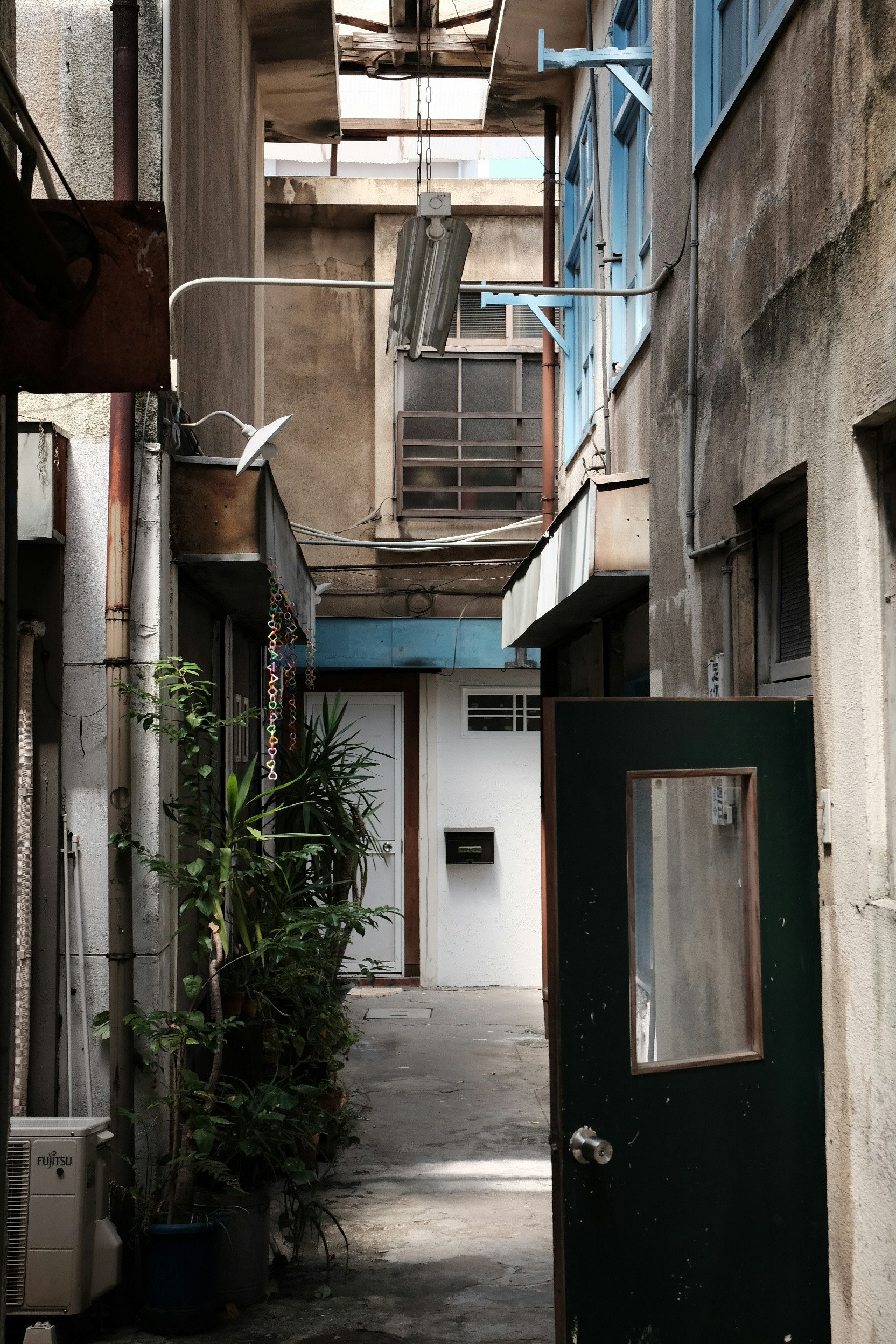 courtyard-like passage with pipes and potted plants