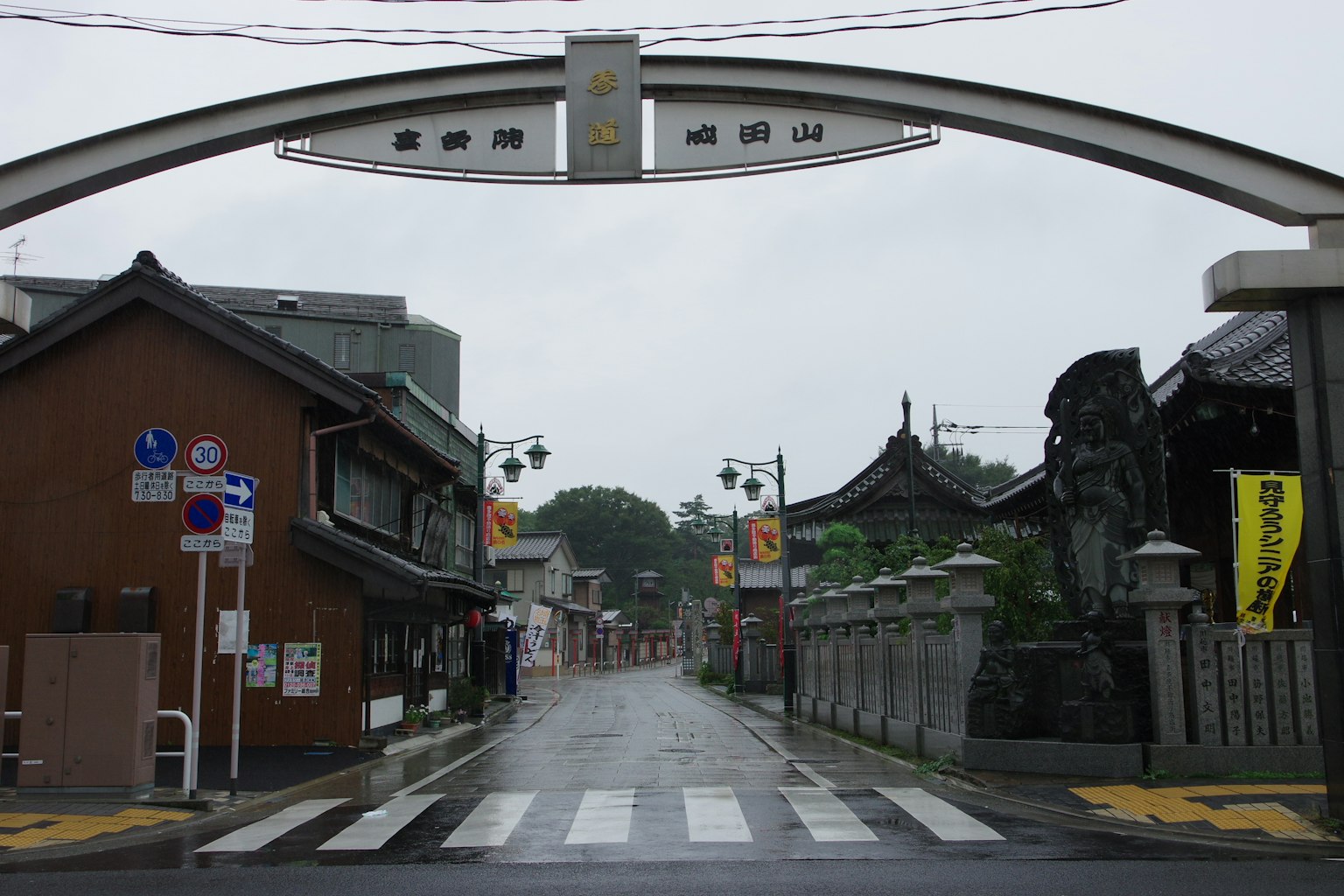 Quiet street with old buildings under rain