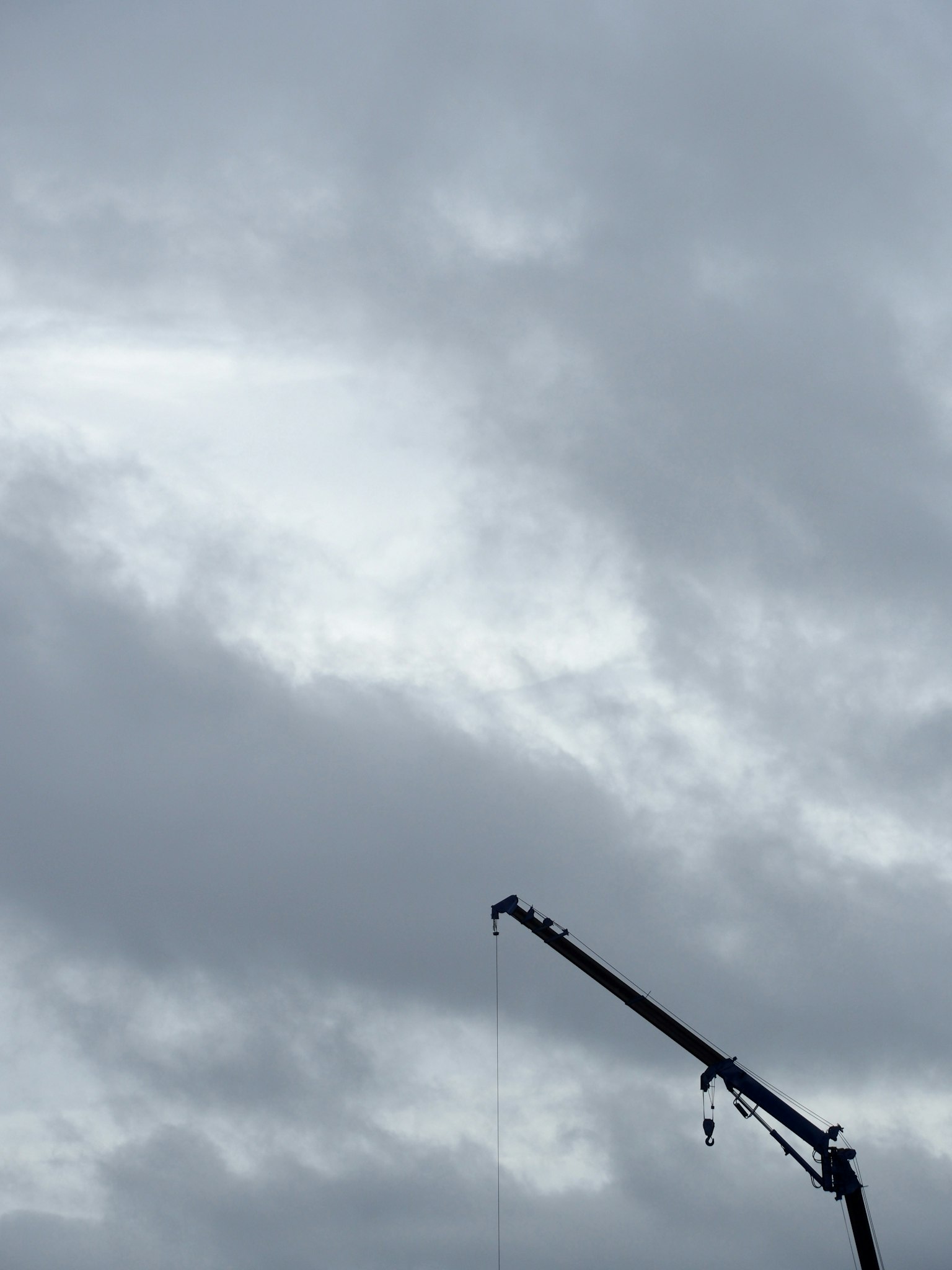 Silhouette d'une grue contre un ciel nuageux