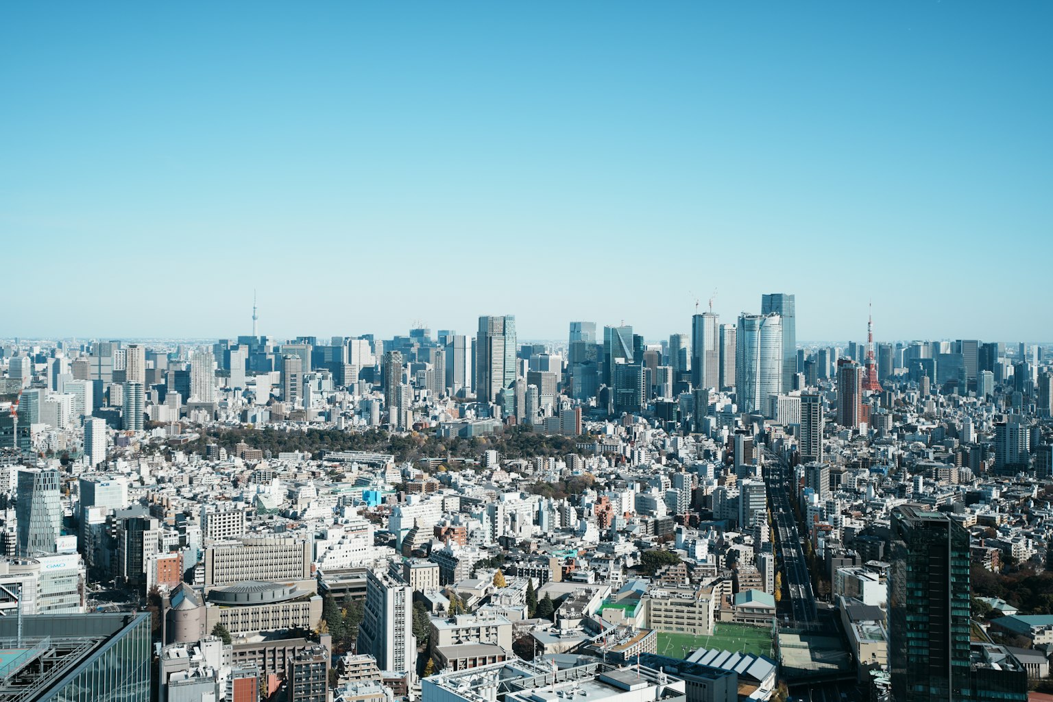 Vast urban landscape of Tokyo under a clear blue sky with skyscrapers