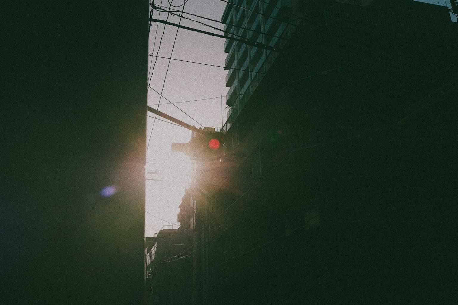 夕日がビルの間から差し込むシルエットの写真