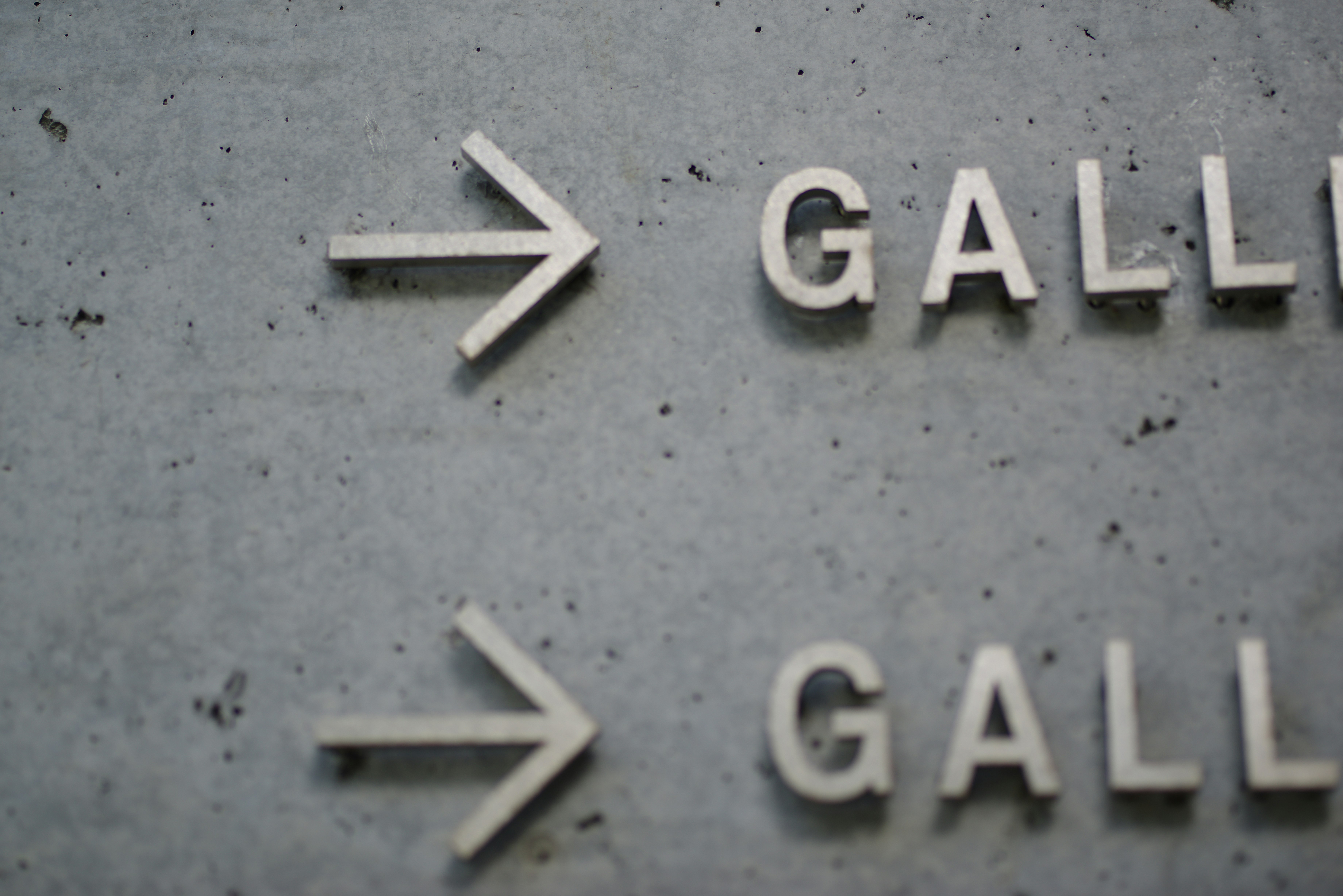 コンクリートの壁に取り付けられた矢印と「GALLERY」の文字