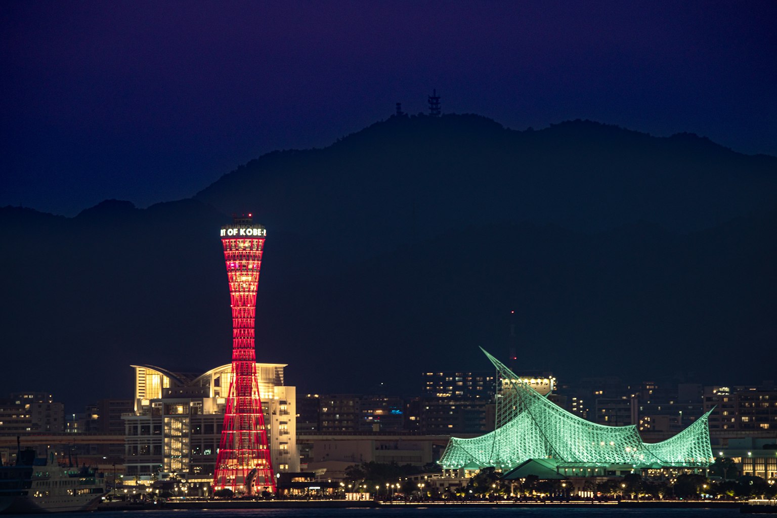 ทิวทัศน์ยามค่ำคืนของหอคอยท่าเรือโกเบและอาคารหลังคาสีน้ำเงิน
