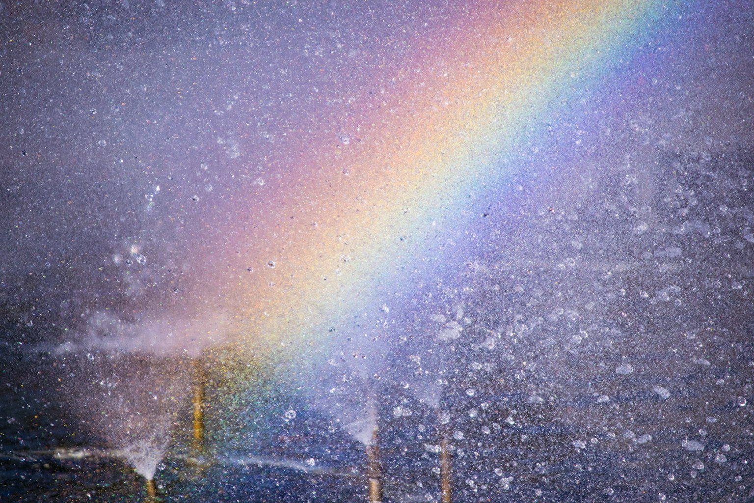 Regenbogen, der durch den Schnee mit einer Stadtlandschaft im Hintergrund zieht
