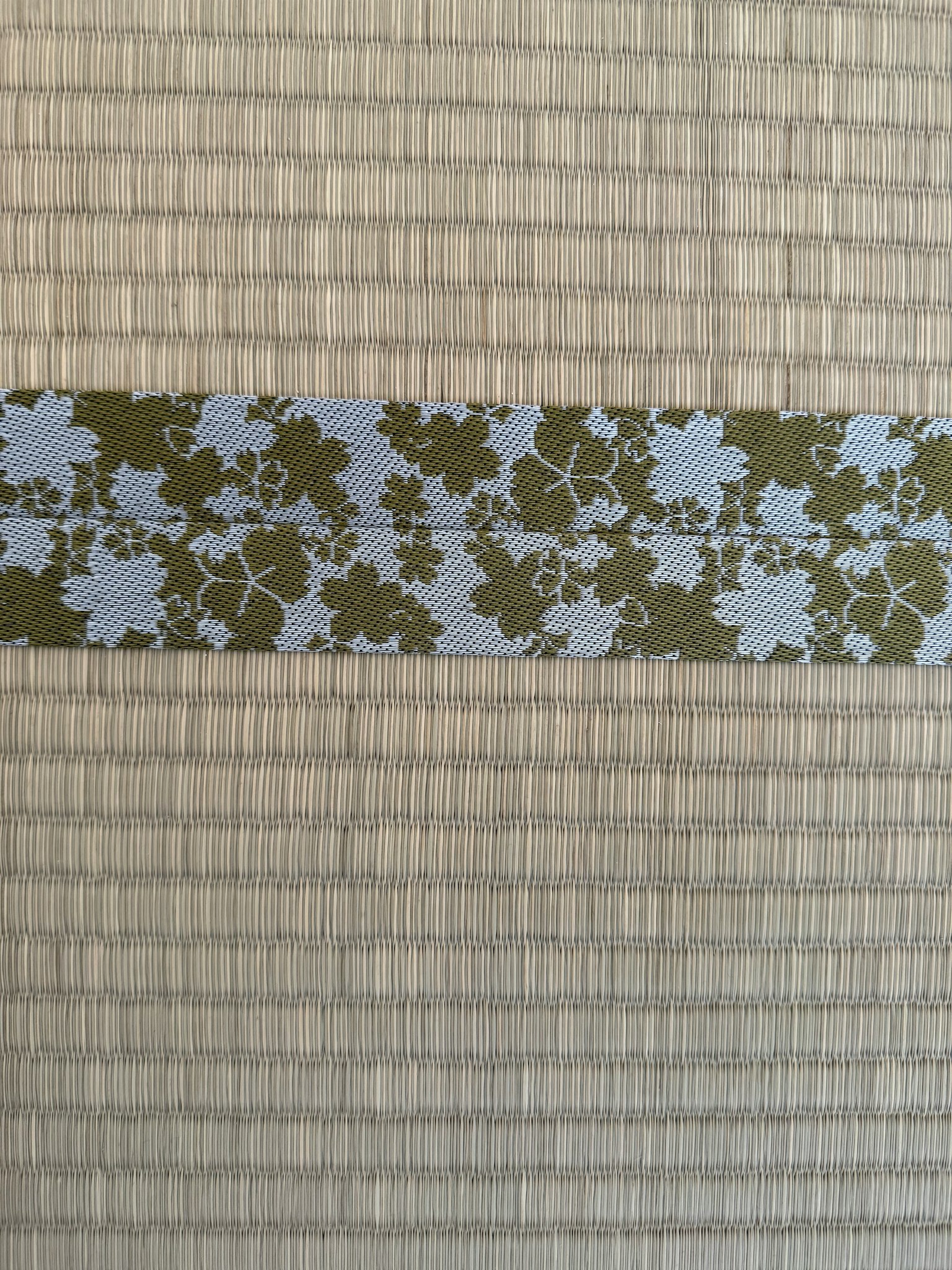 Un ruban floral posé sur un fond beige texturé