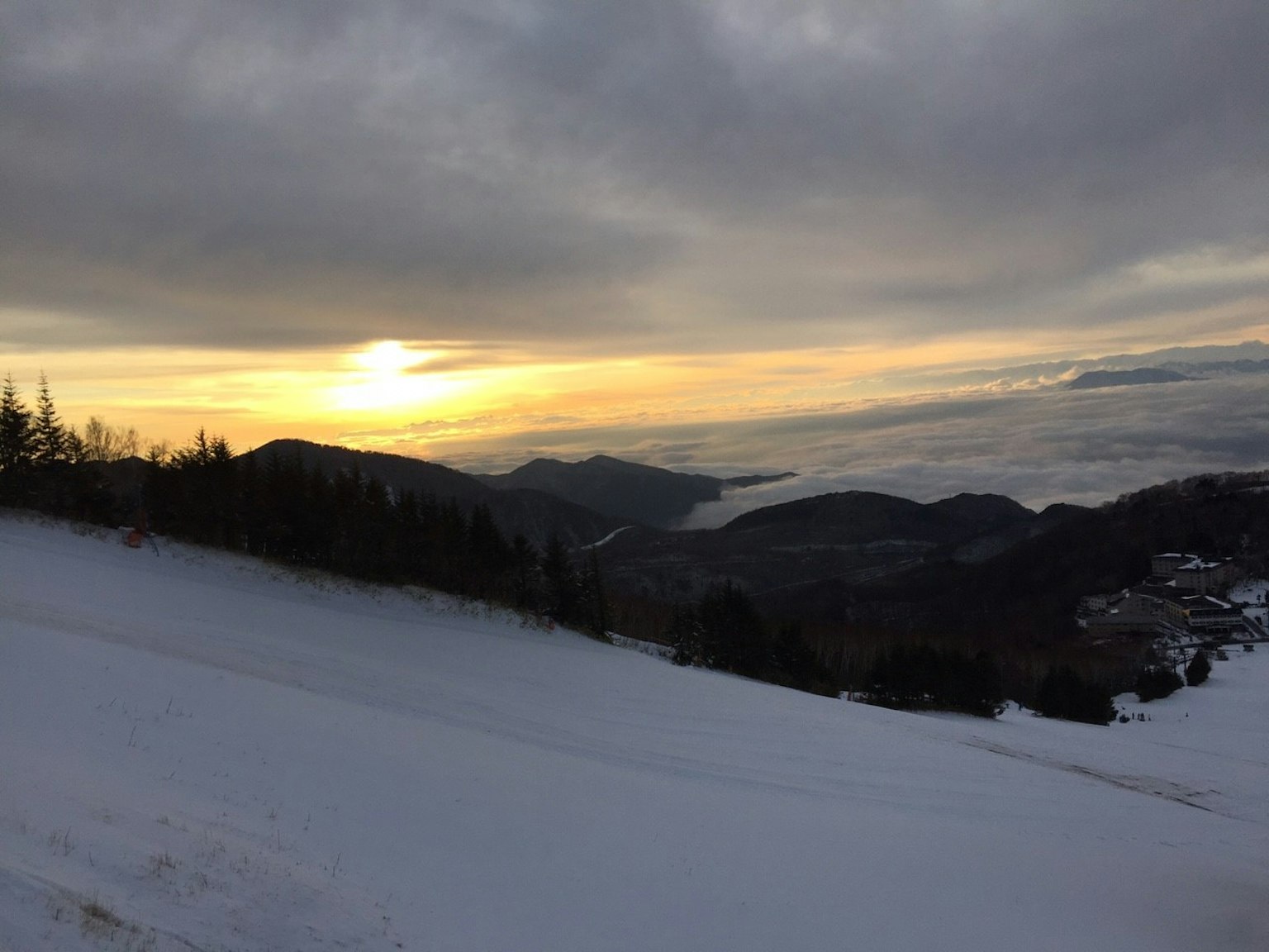 Paisaje montañoso cubierto de nieve con atardecer