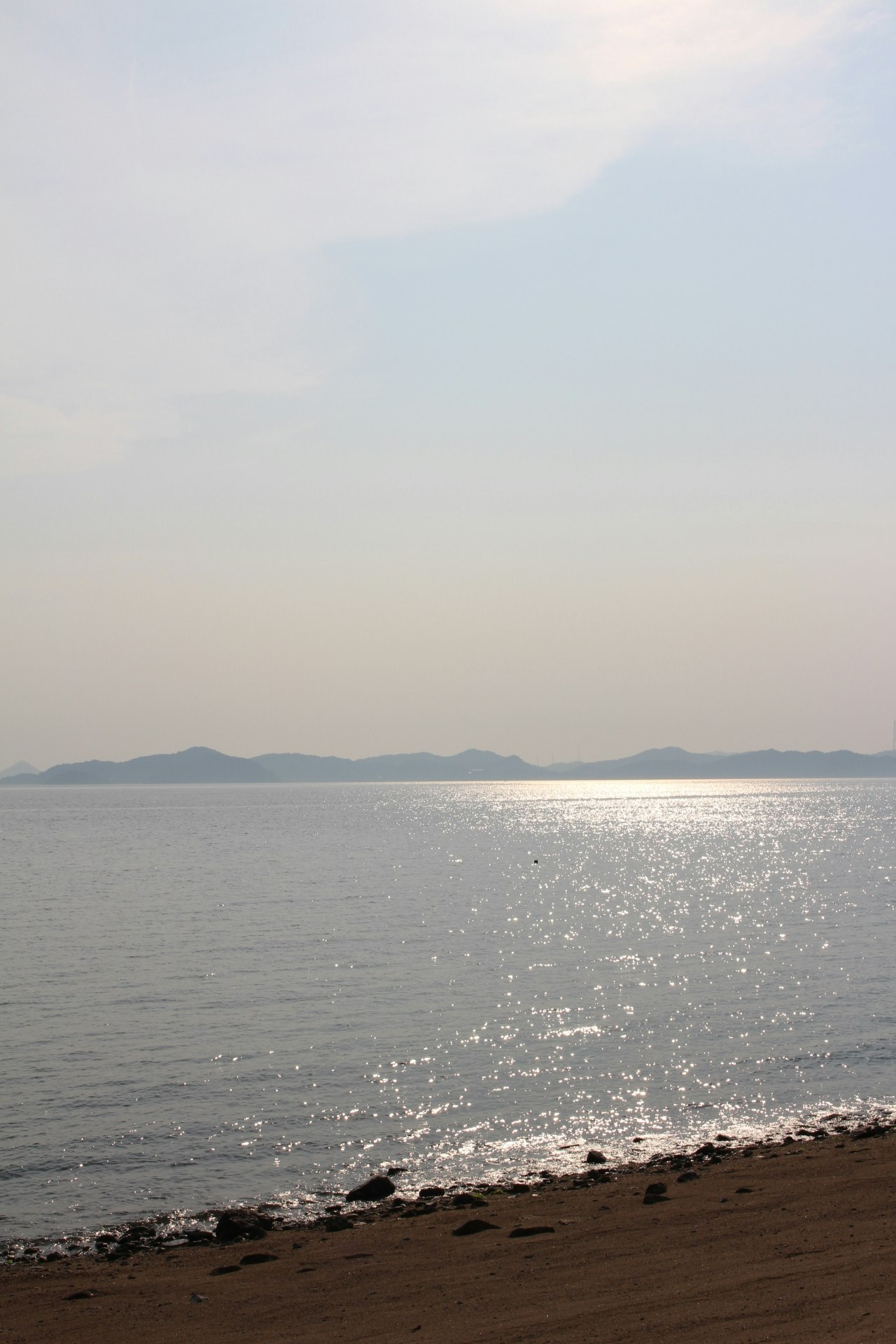 海辺の砂浜から望む穏やかな海と水平線
