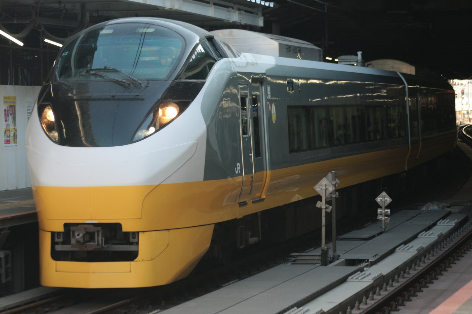 รถไฟด่วนที่มีการออกแบบสีเหลืองและขาวจอดอยู่ที่สถานี