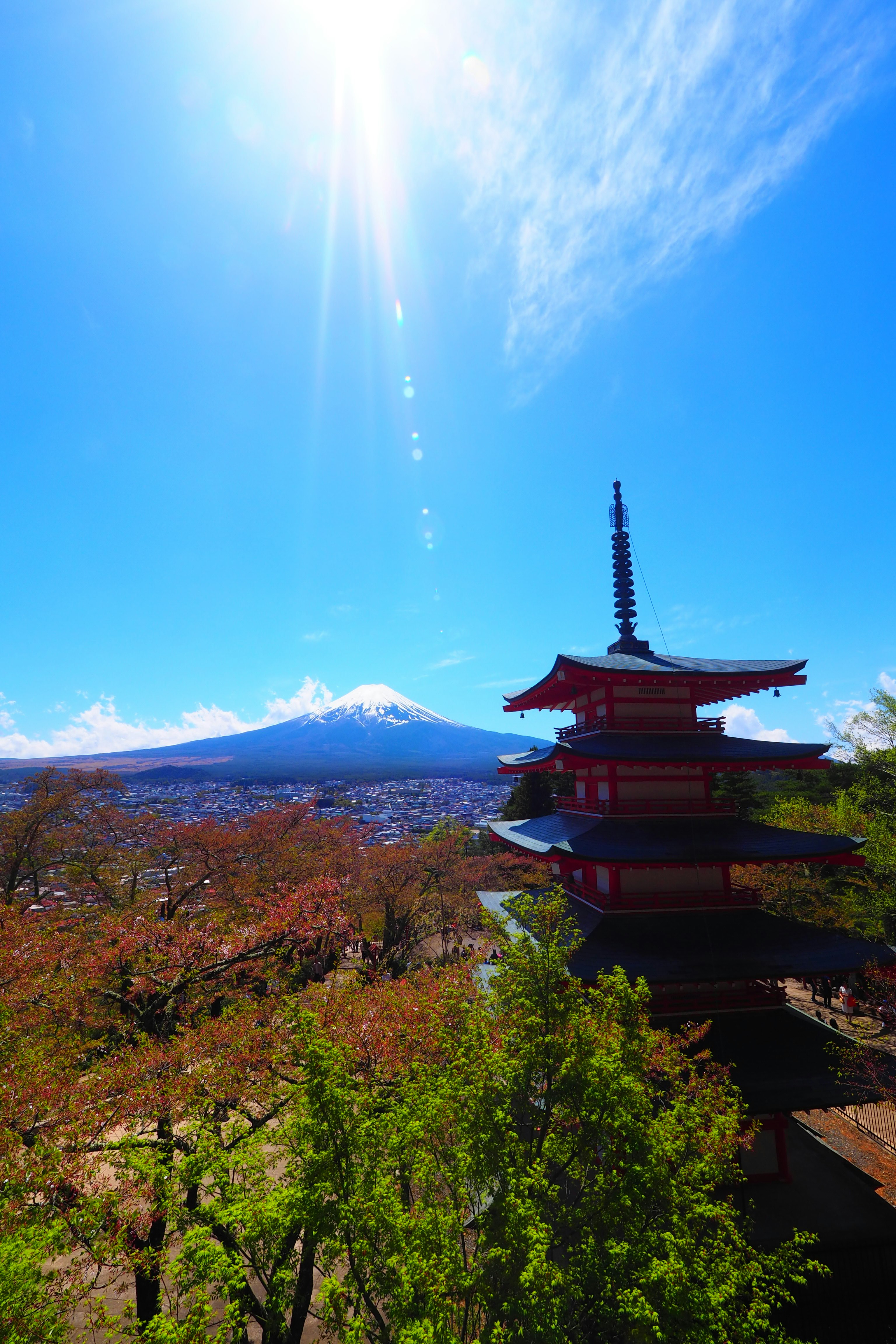 Five-story pagoda with autumn foliage and distant mountains under a blue sky