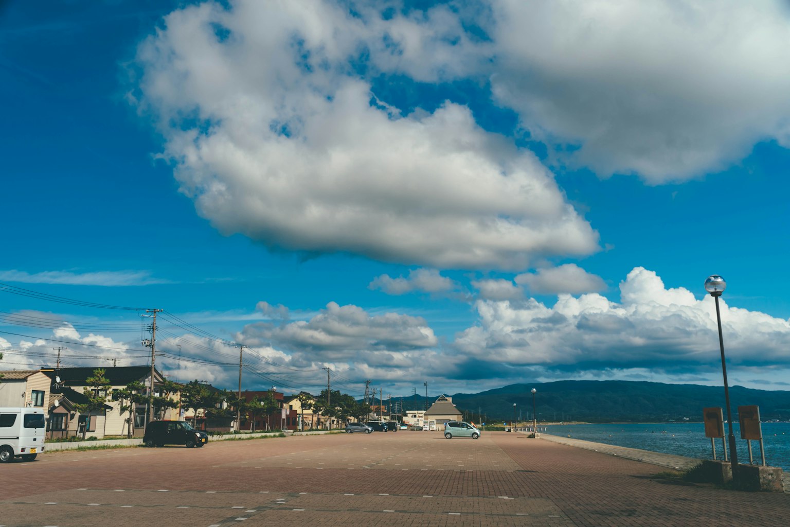 Strandszene mit blauem Himmel und Wolken, die den Sandstrand und die Küstenlinie zeigt