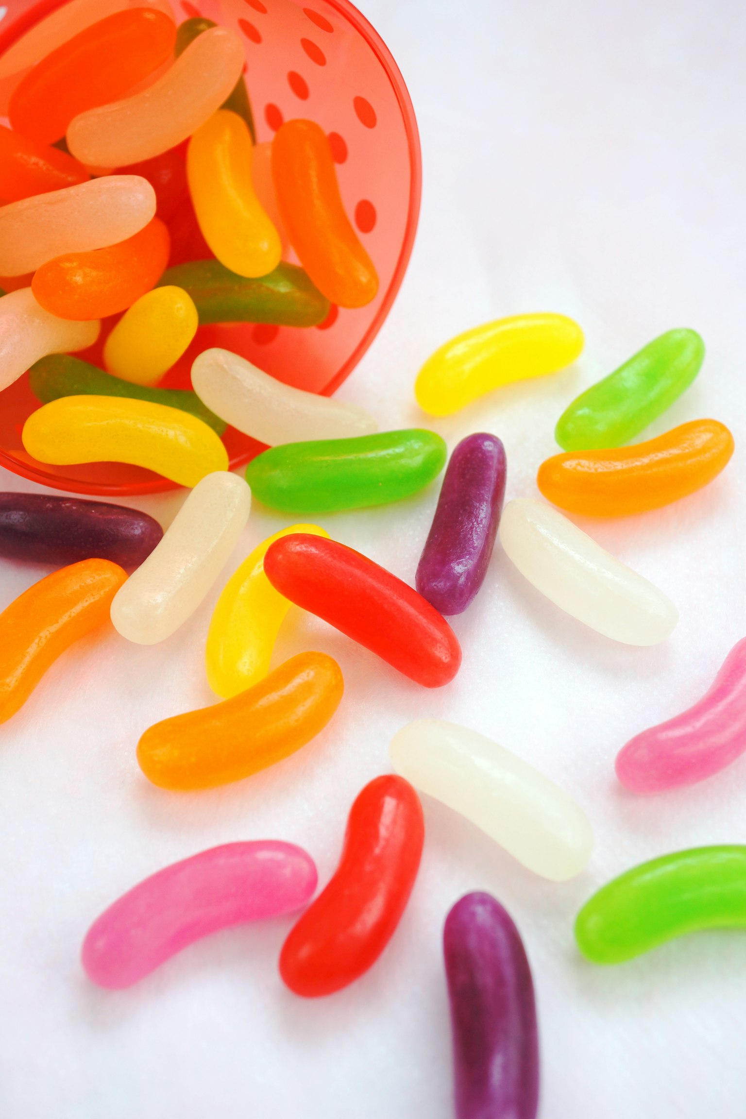 Colorful jelly beans scattered on a white surface