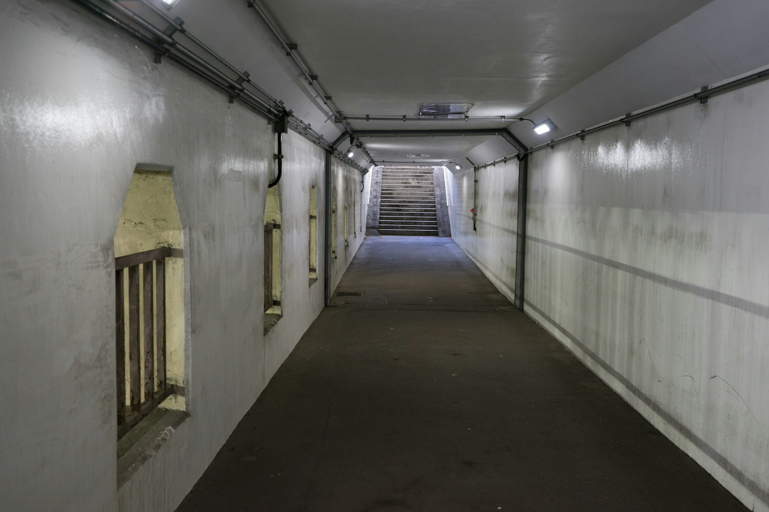 Heller Tunnel mit weißen Wänden und Treppe am Ende