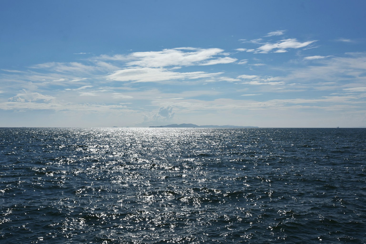 Paesaggio di mare e cielo blu con riflessi di luce sulla superficie dell'acqua