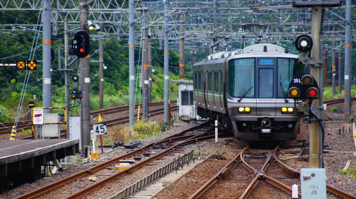 信号機のある線路上を走る電車の前景