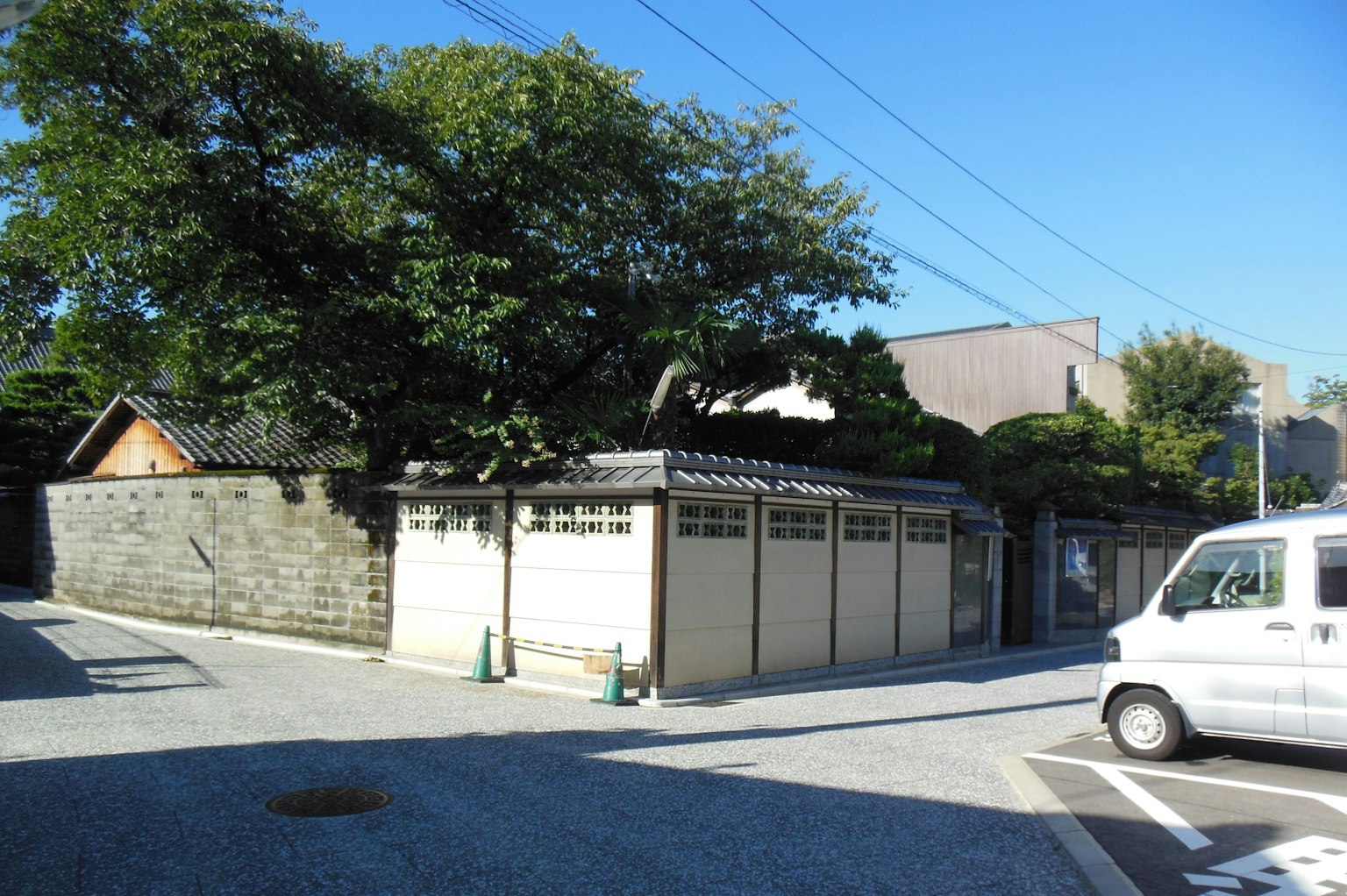 Traditionelles japanisches Haus an einer ruhigen Straßenecke mit Bäumen