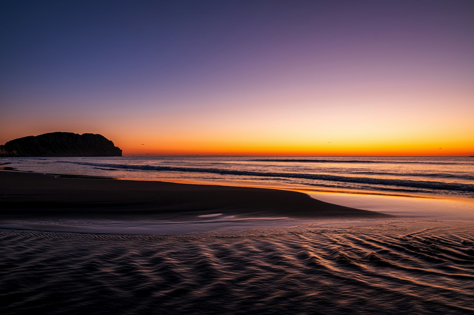 Cảnh biển yên bình với màu sắc hoàng hôn phản chiếu trên mặt nước