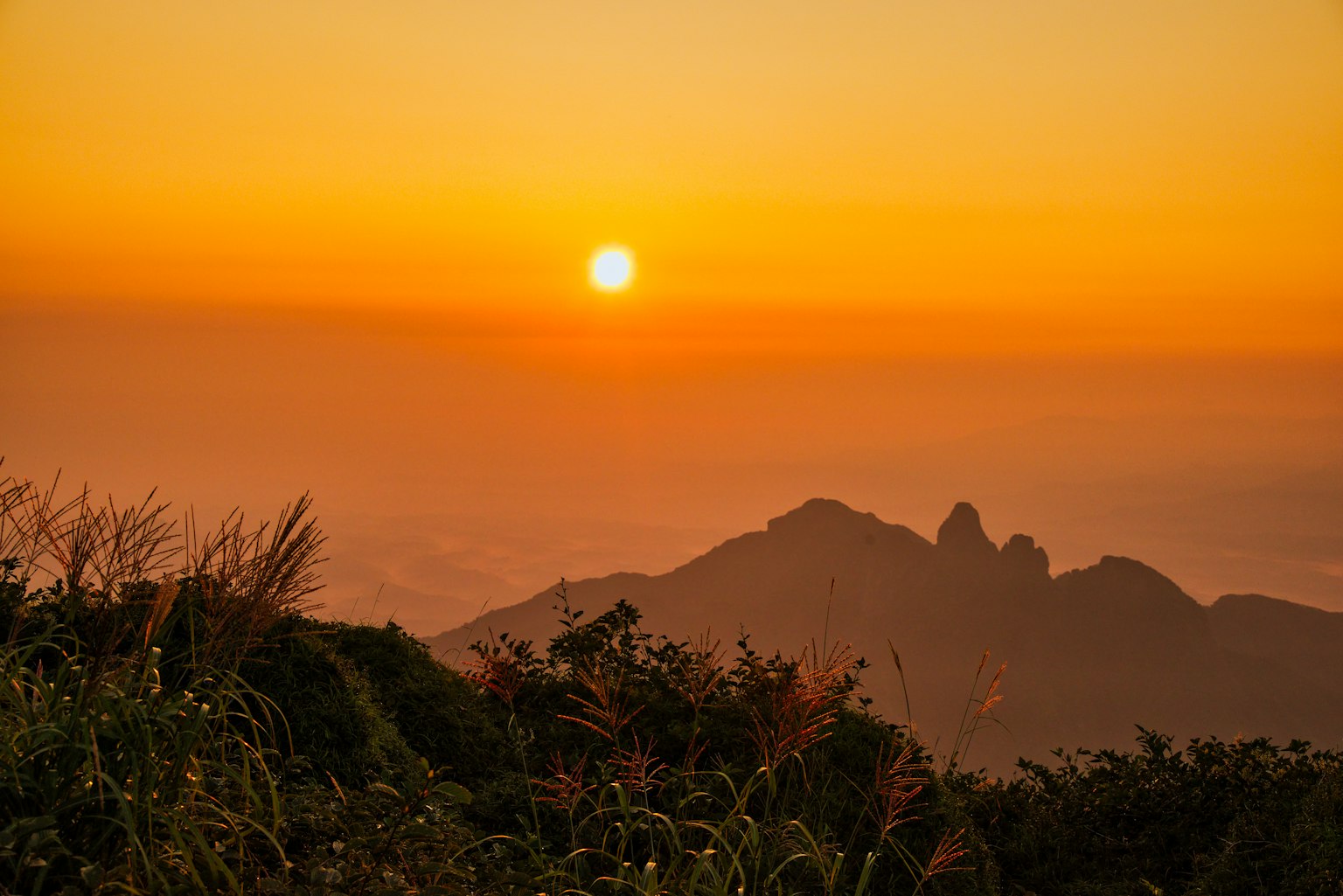 Silueta de montañas contra un cielo de atardecer naranja