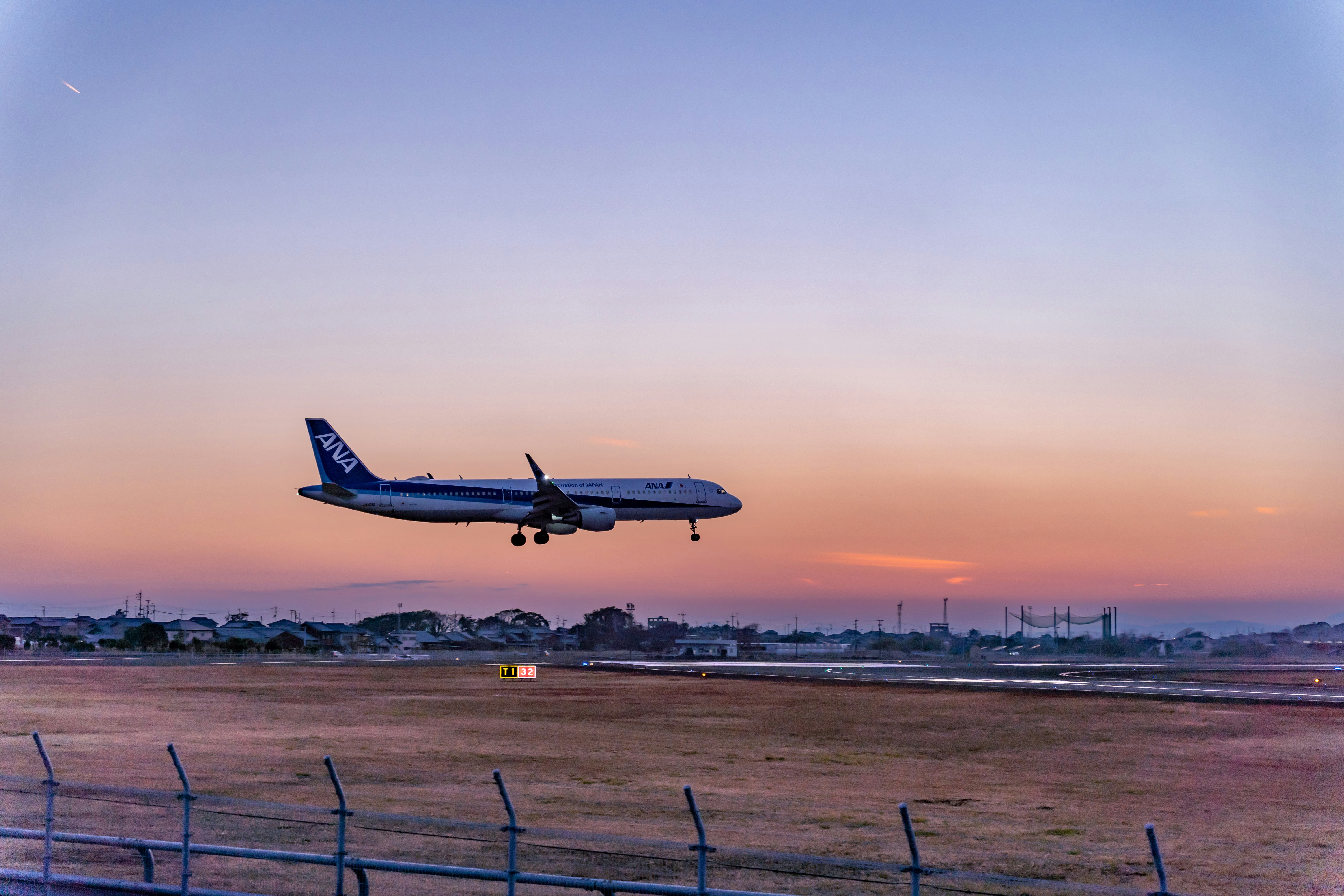 夕陽下機場跑道上飛機起飛瞬間