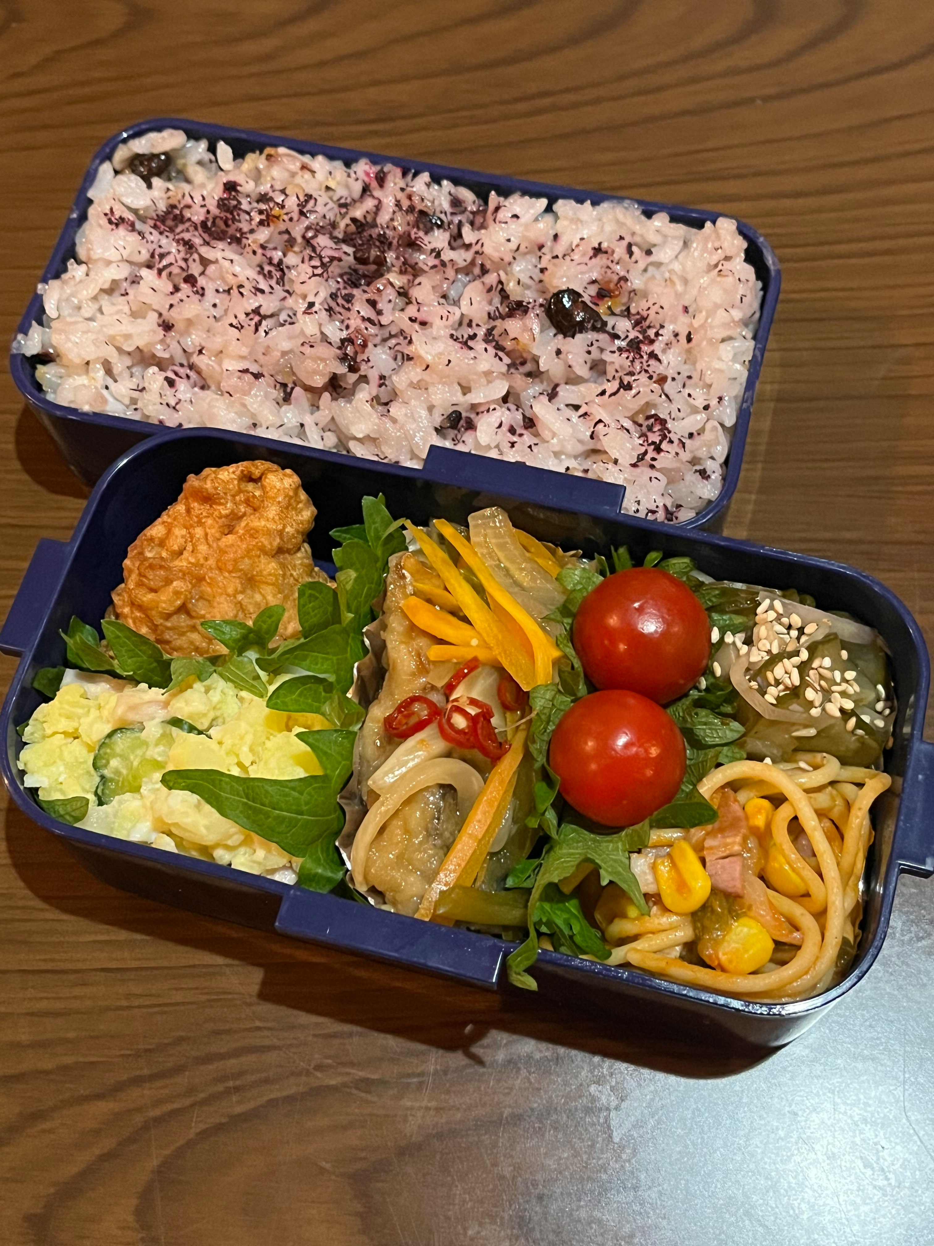 便當盒裡的彩色蔬菜、義大利麵和米飯