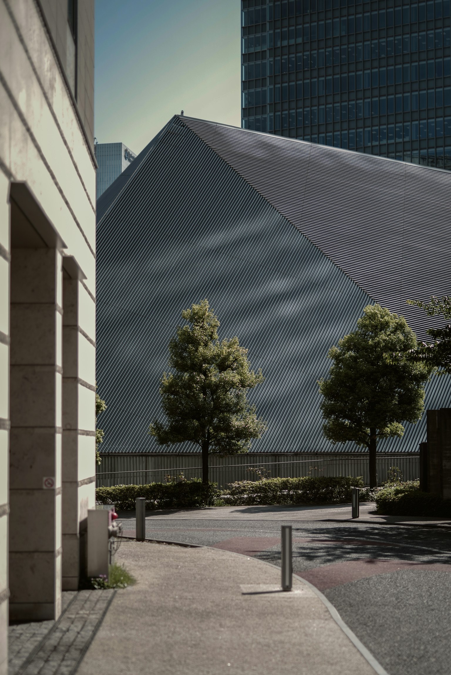 Scena urbana con un edificio moderno dal tetto triangolare e alberi