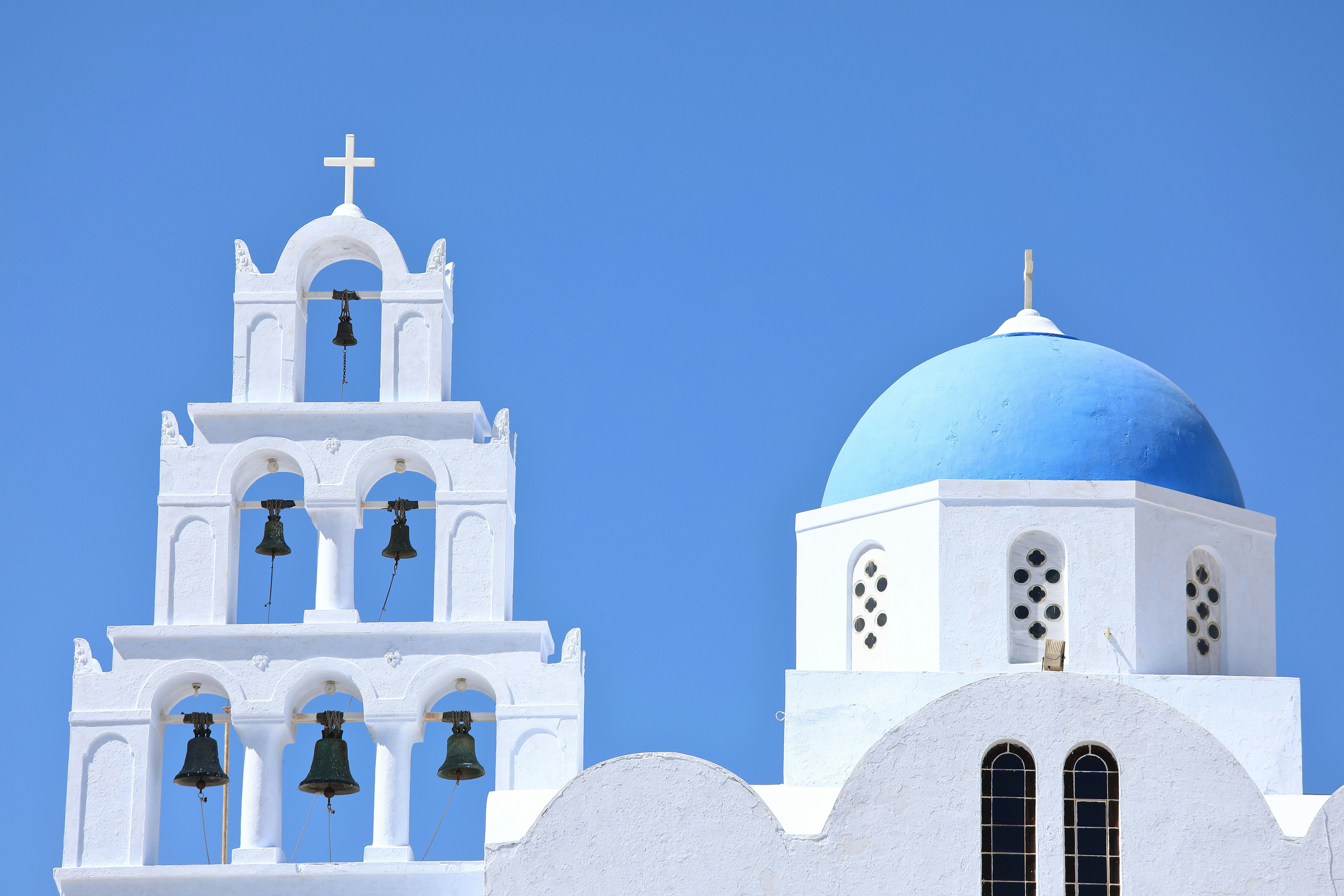 Fira church facade with white-and-blue architecture and bells