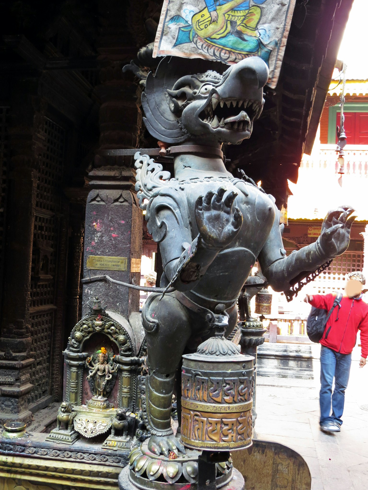 Bronze lion statue at temple entrance with intricate details