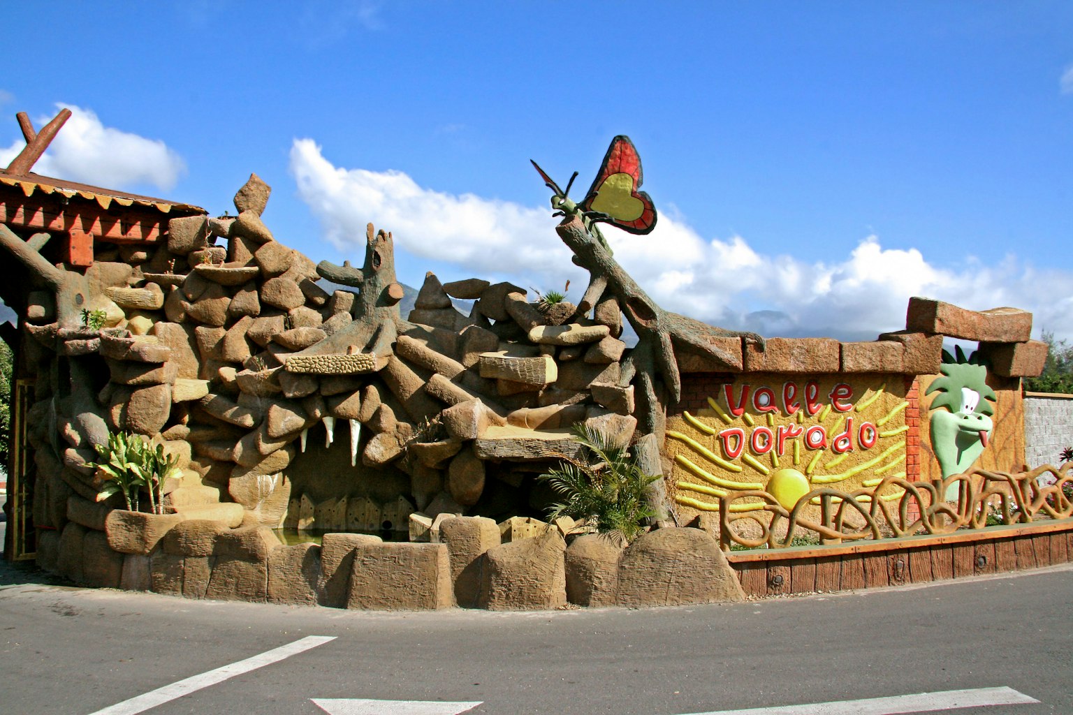 Mural de papillon coloré et sculptures en pierre naturelle à l'entrée