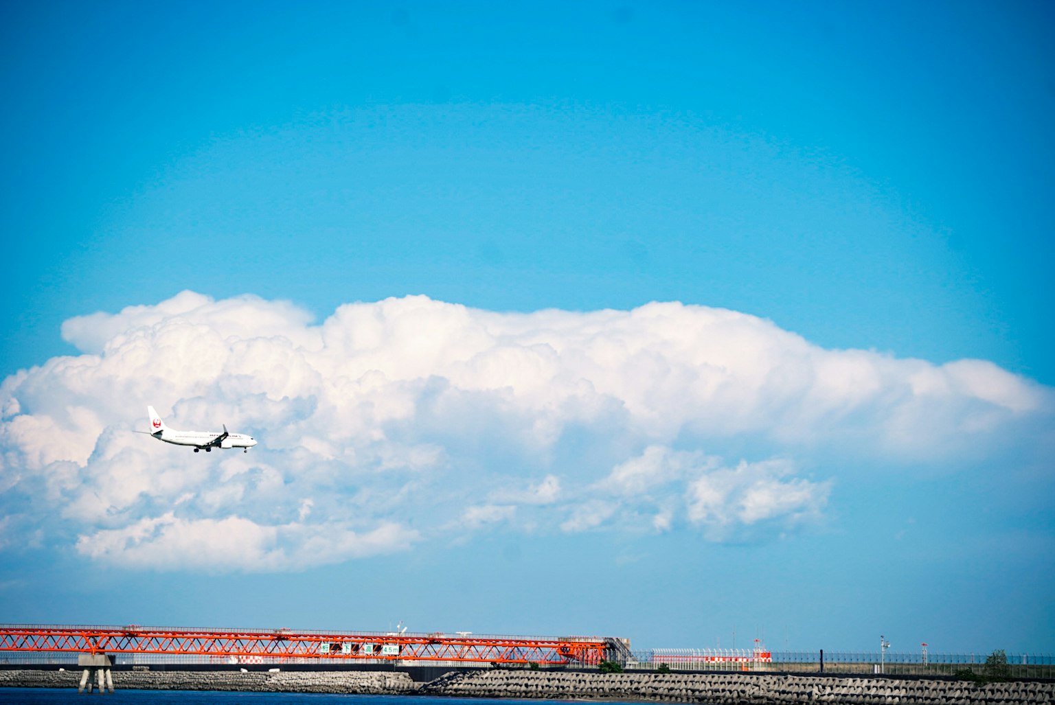 Aereo che vola in un cielo blu con nuvole bianche soffici