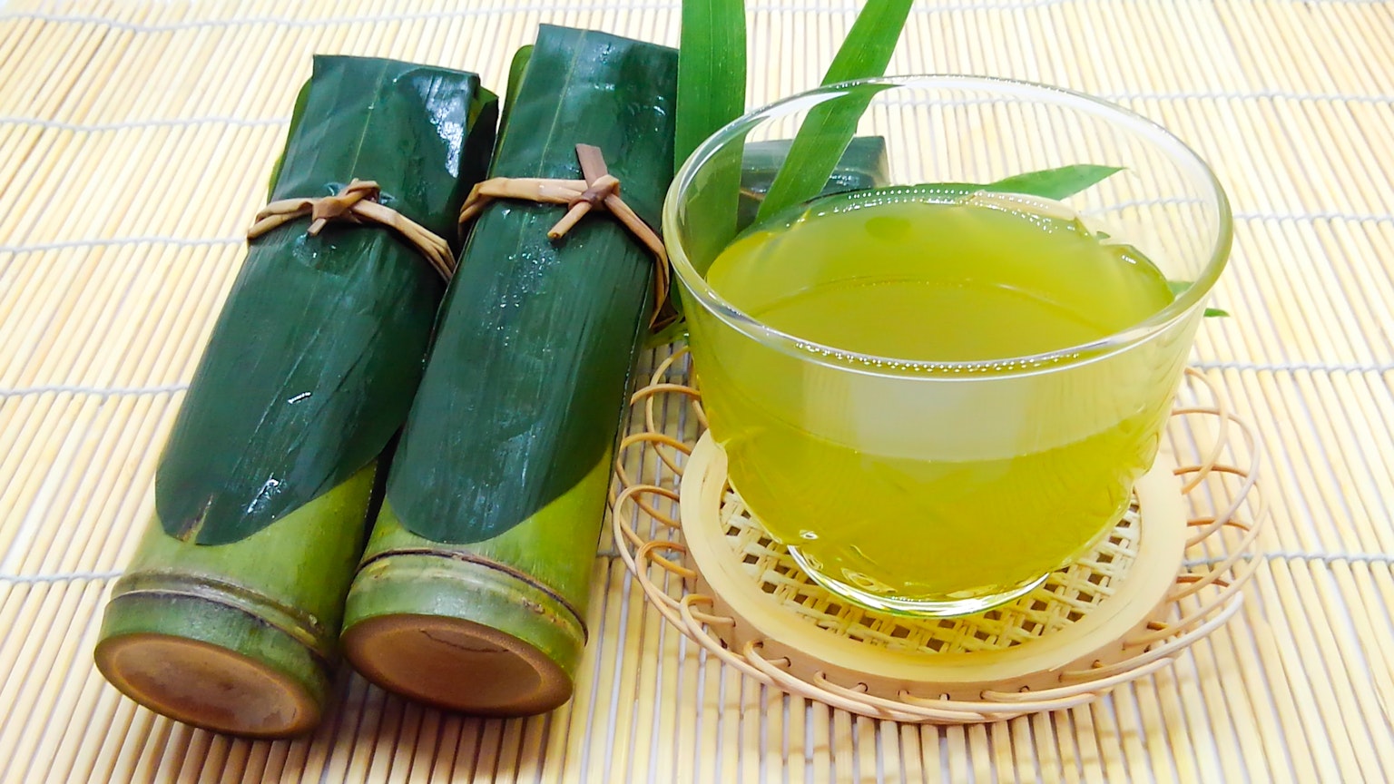 圖像中有綠色飲料的玻璃杯和竹製容器