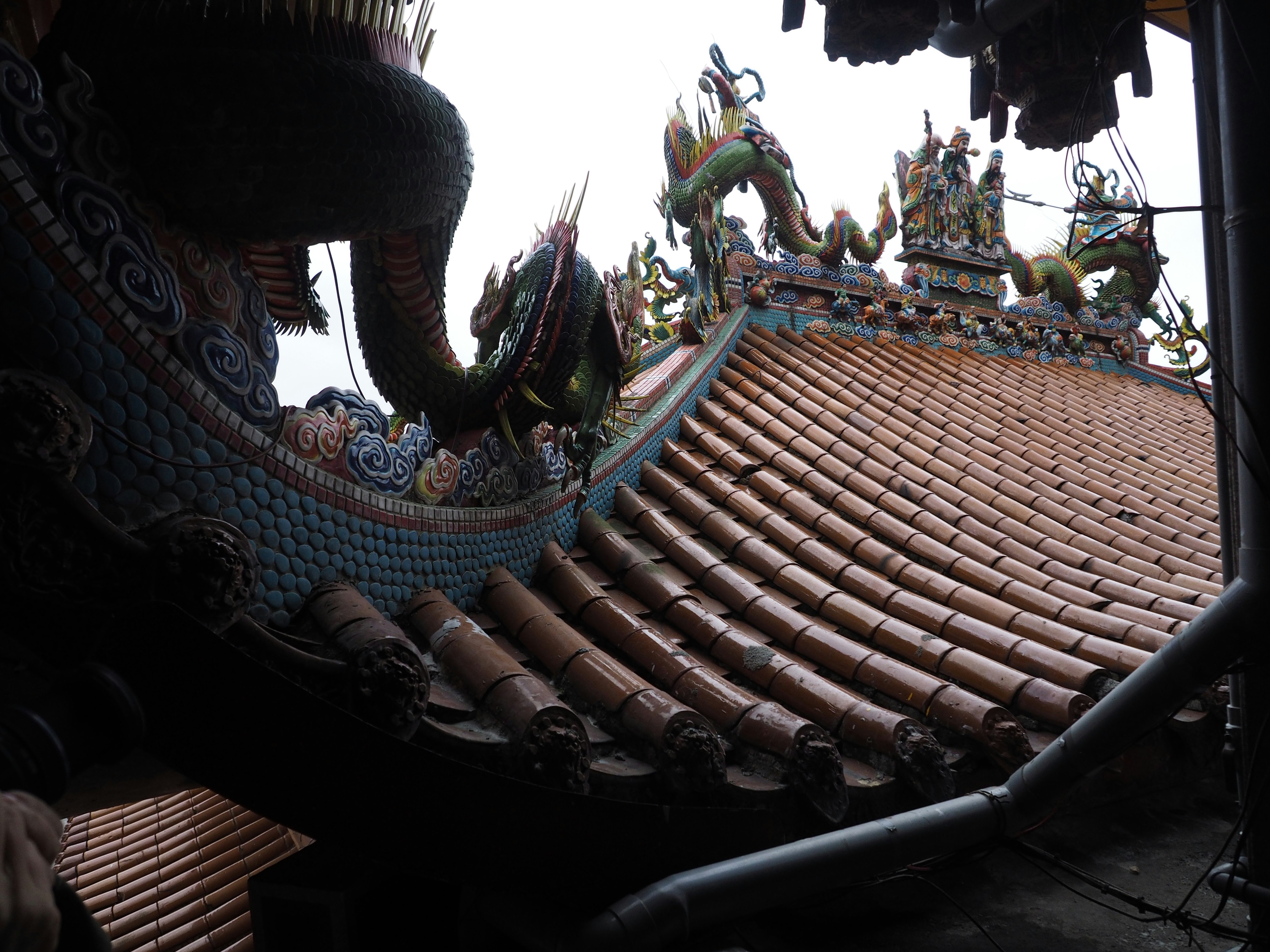 Interior view of a temple showcasing tiled roof and ornate sculptures