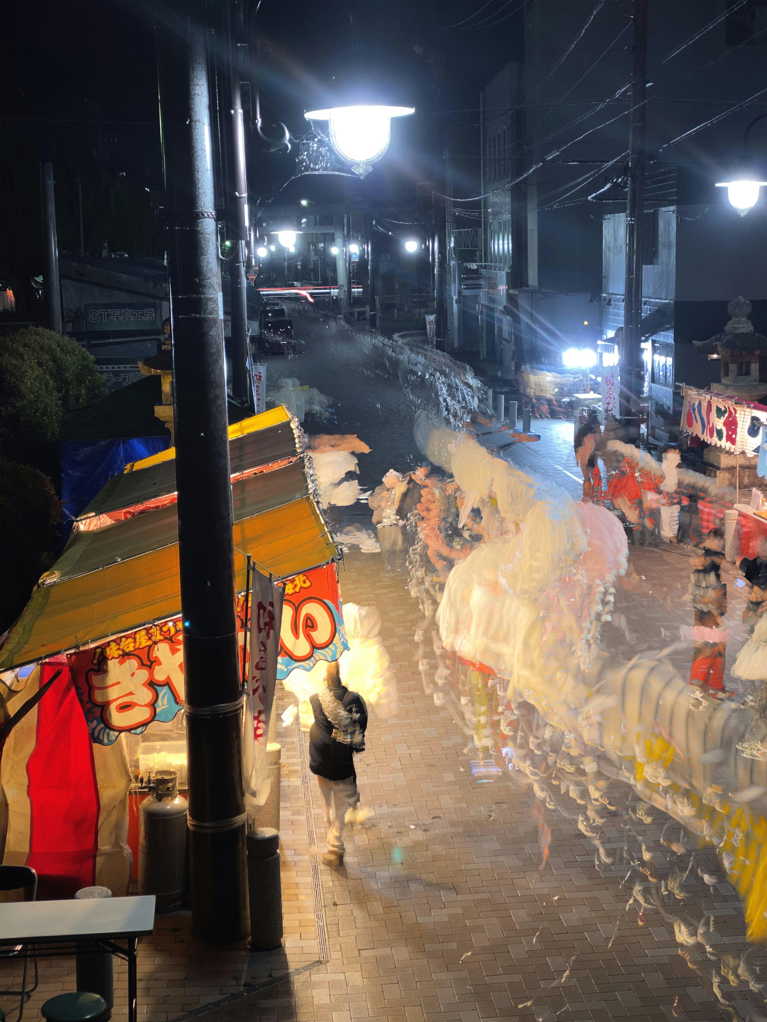夜の路地で神社参拝の行列とお正月飾りのある風景