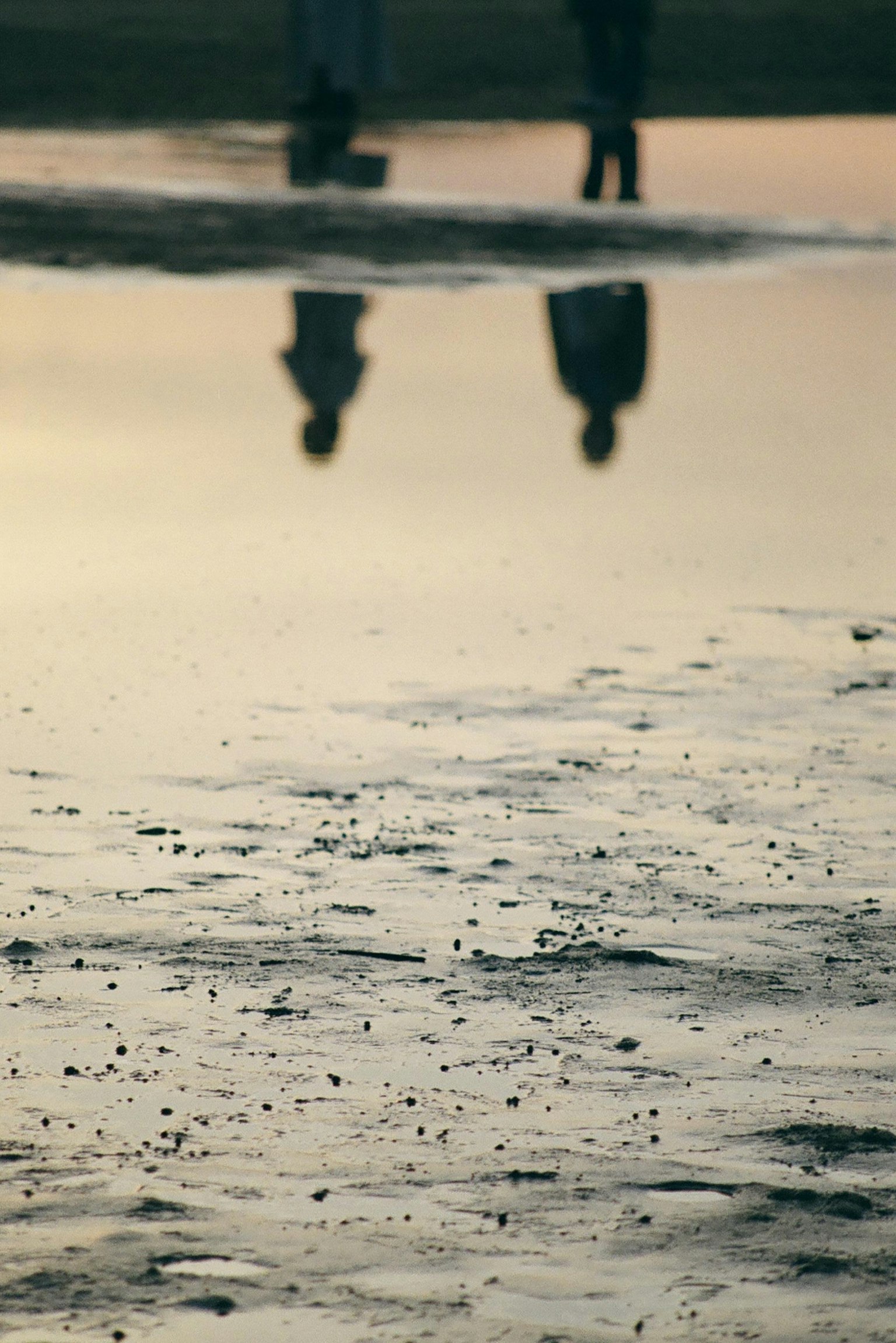 Due figure che camminano vicino all'acqua con i loro riflessi