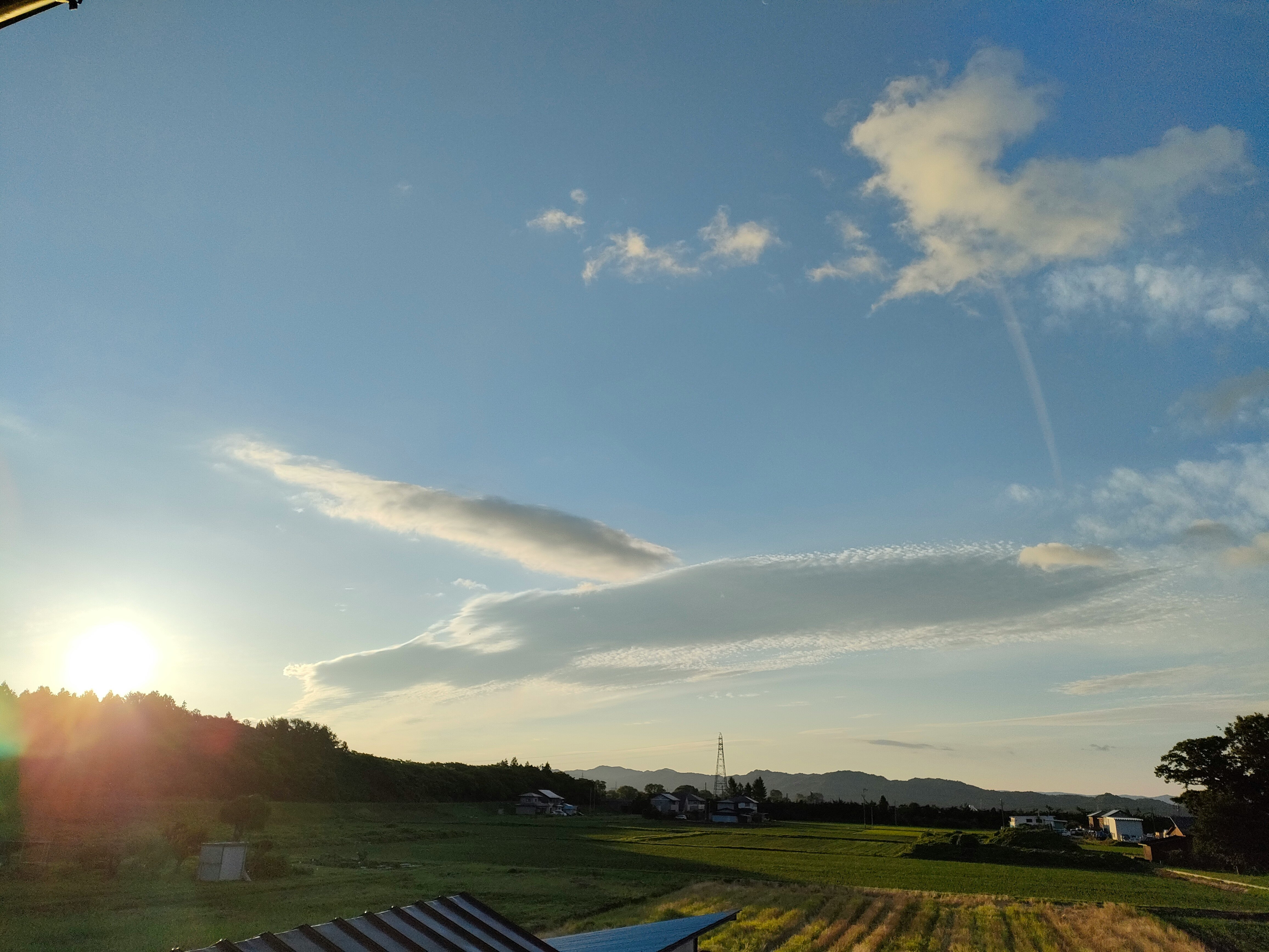 夕日に照らされた田園風景と遠くの教会の尖塔