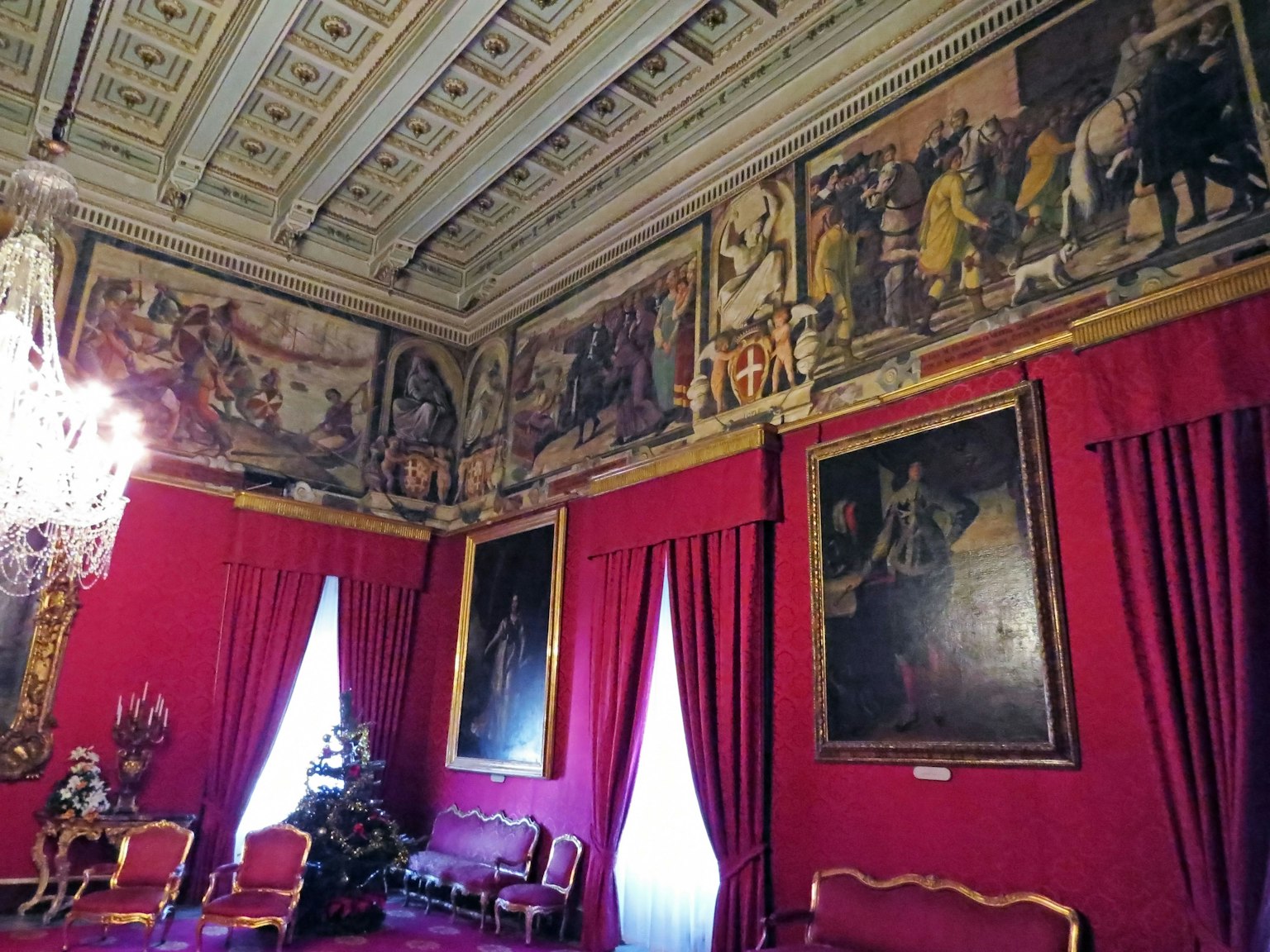 Luxurious room interior with wall murals and gold-framed paintings Crystal chandelier hanging from the ceiling