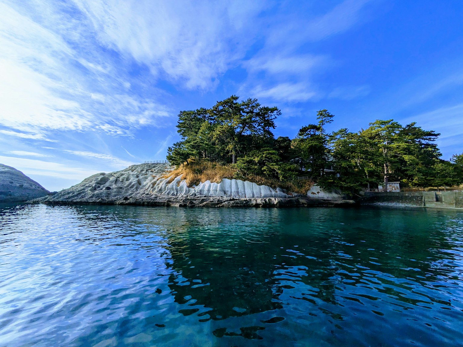 Vista escénica de una pequeña isla rodeada de aguas tranquilas y cielo despejado