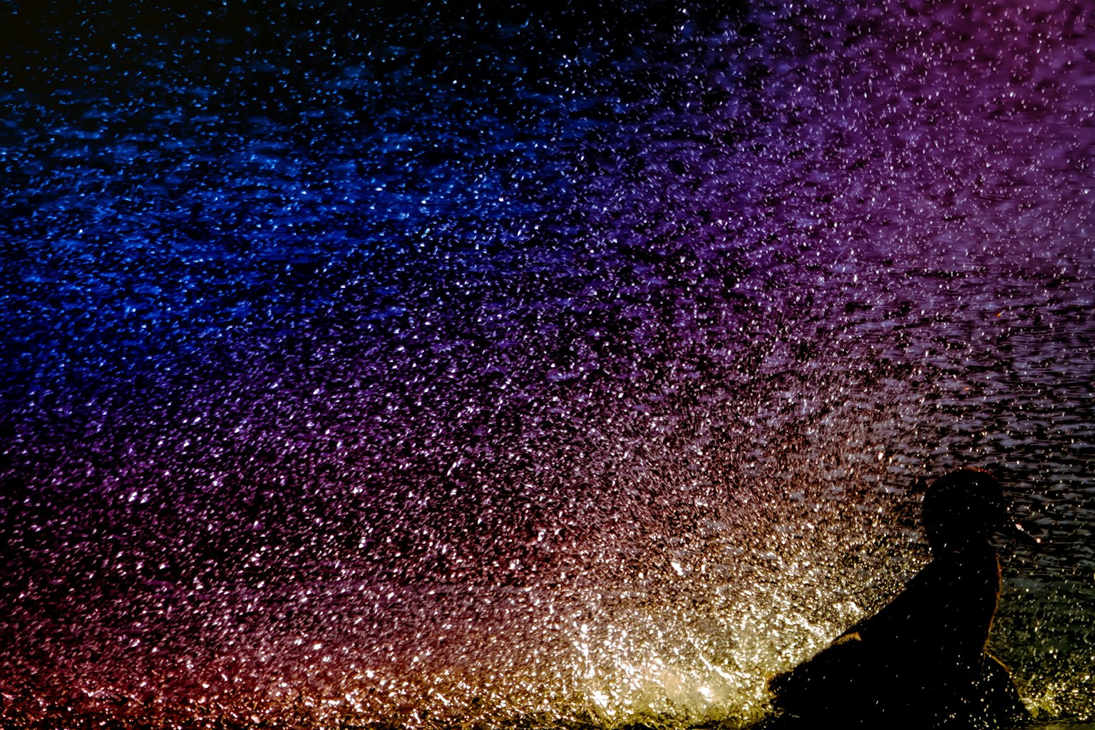 Una silhouette contro uno sfondo colorato di luci scintillanti