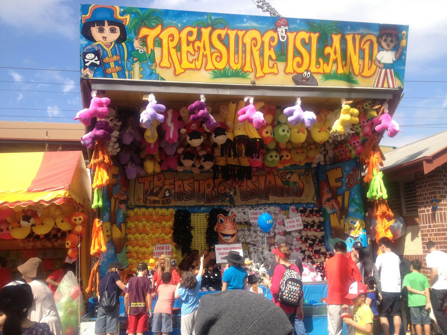 Gian hàng trò chơi đầy màu sắc mang tên Treasure Island với trẻ em tập trung xung quanh