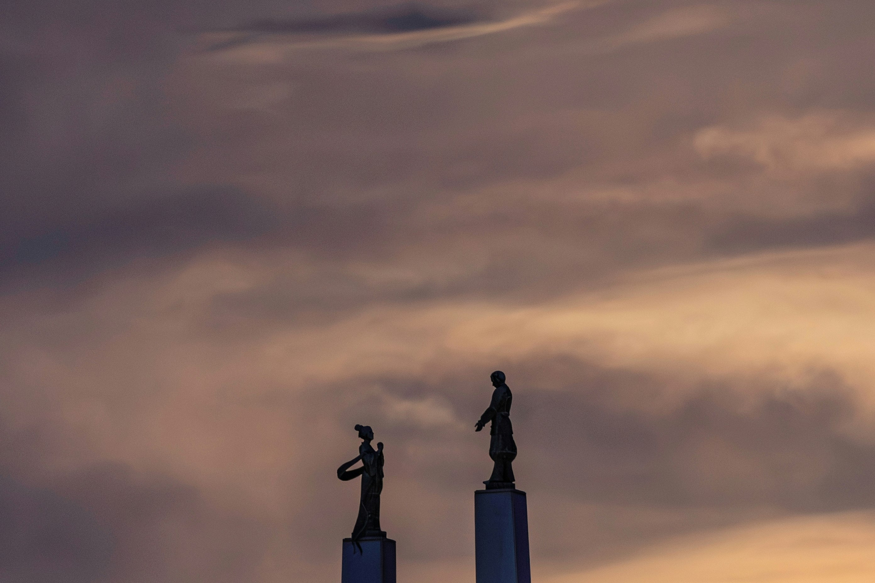 夕暮れの空にそびえる彫像のシルエット