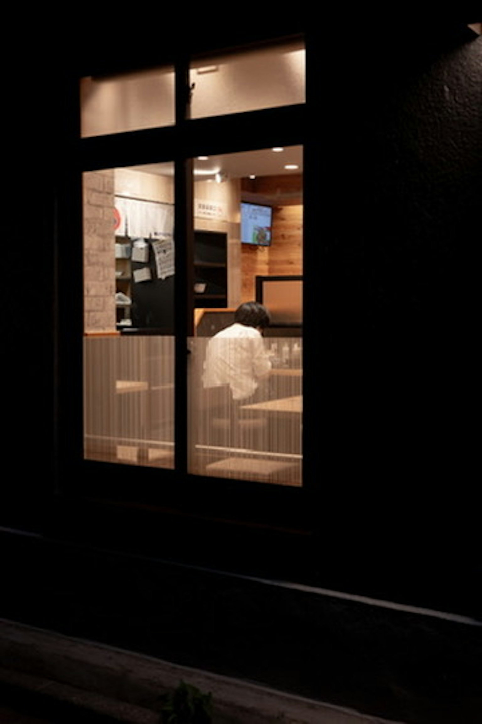Acogedor interior de madera de un café visible a través de un exterior oscuro