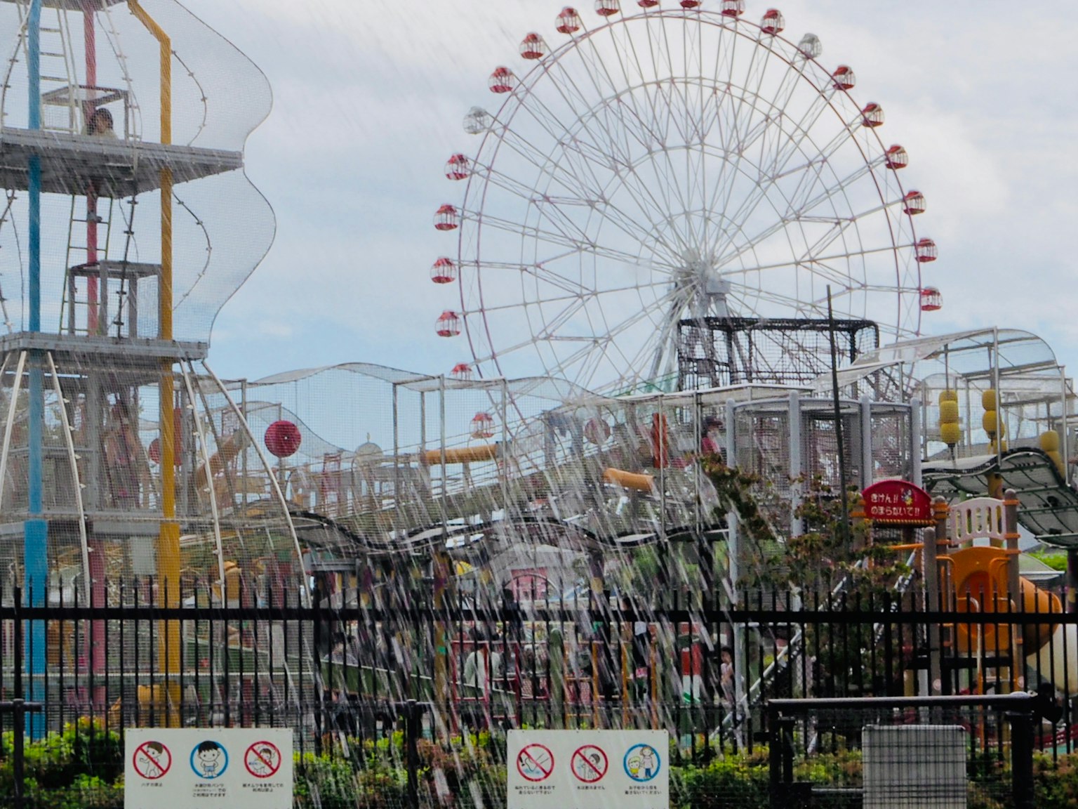 Vista de un parque de atracciones con una noria y varias atracciones