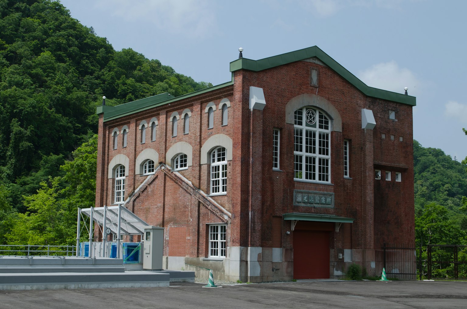 붉은 벽돌 건물과 녹색 산 배경
