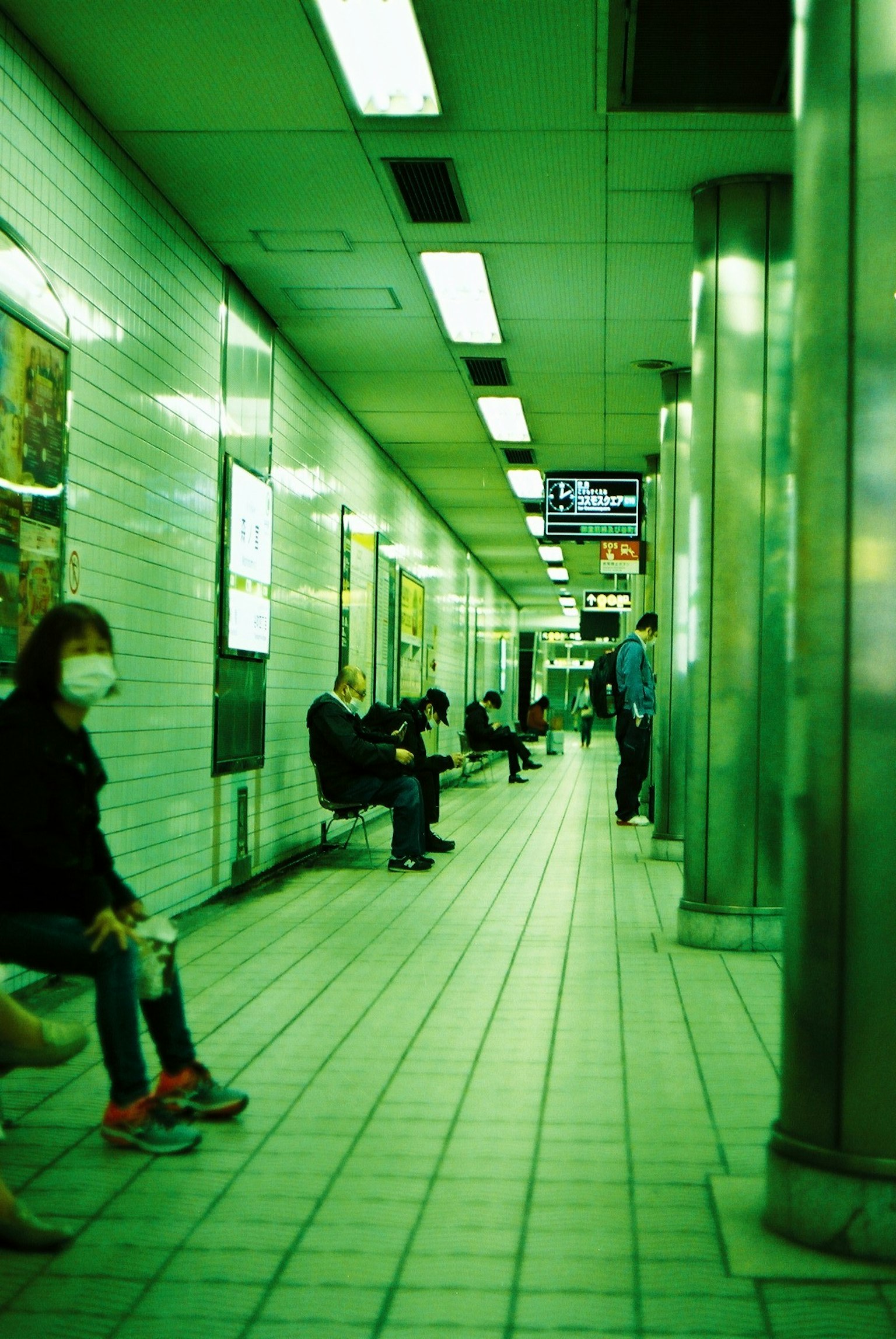 Menschen sitzen auf einer U-Bahn-Plattform mit grünem Licht